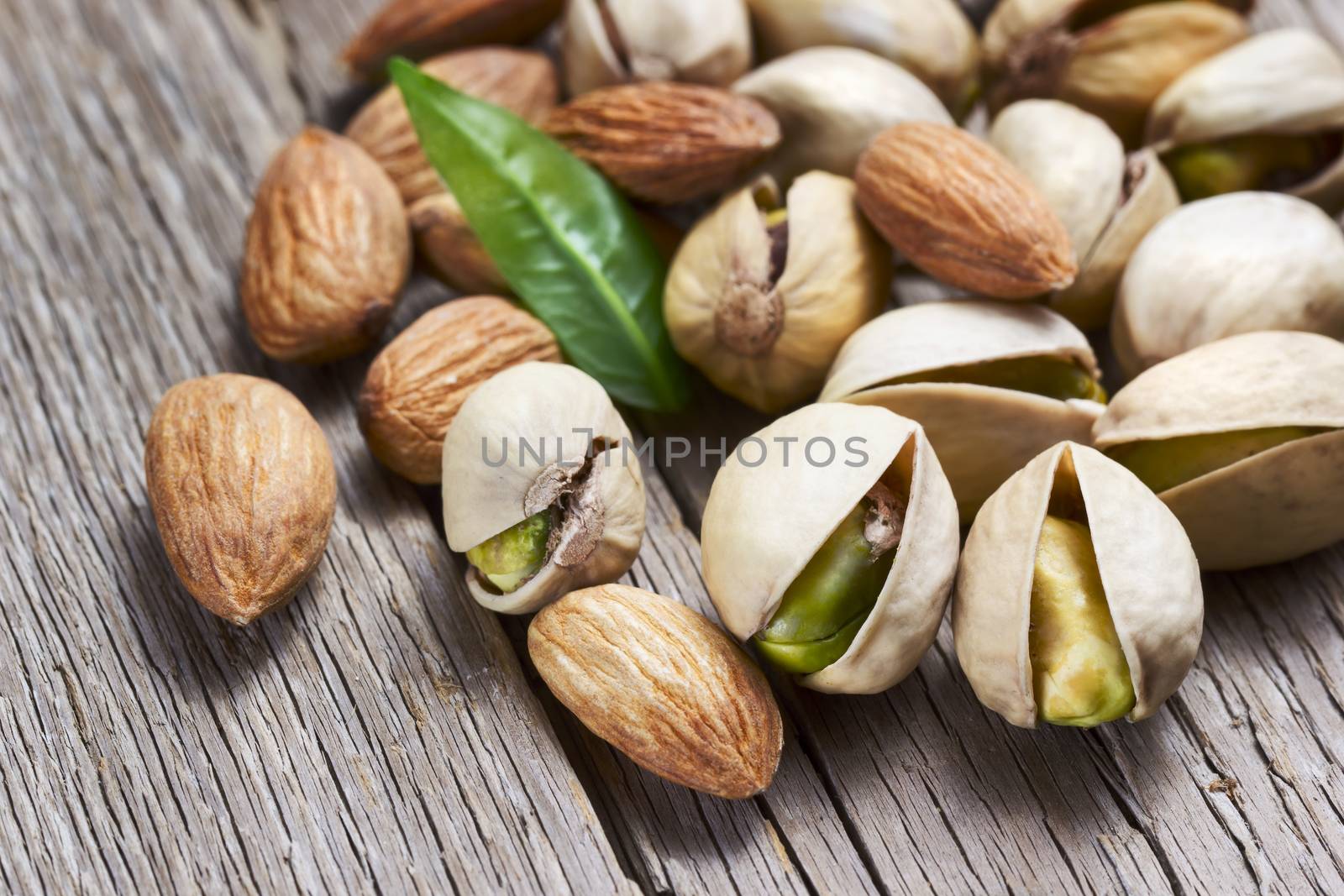Almonds and pistachios with leaf by Valengilda