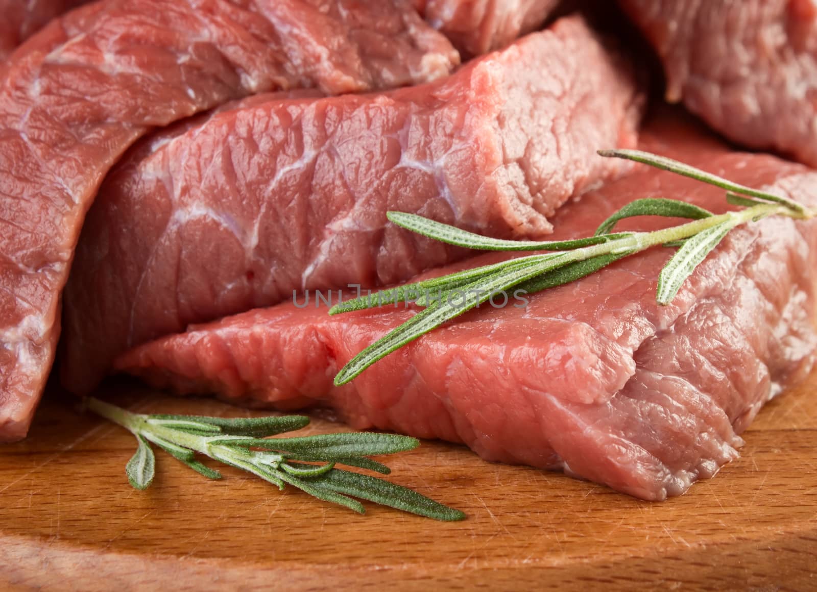 Raw meat with rosemary on cuttting board