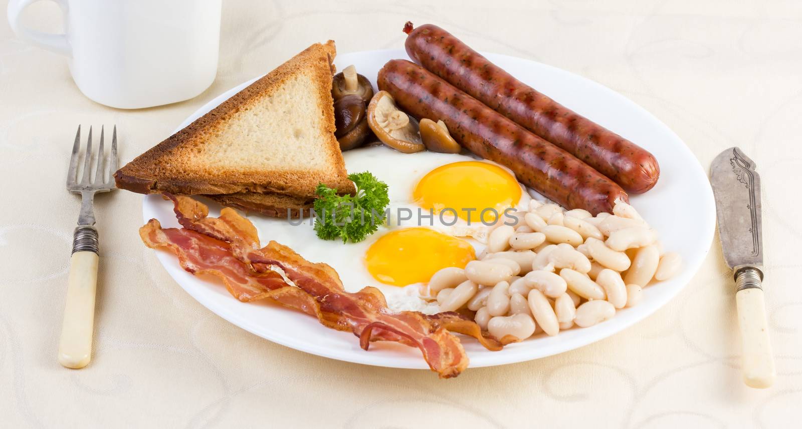 English breakfast: eggs, beans, sausages, bacon and mushrooms