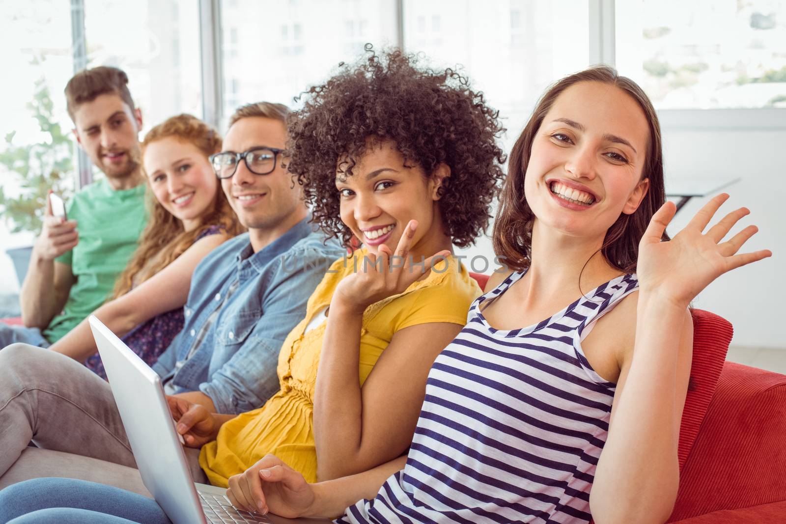 Fashion students smiling and waving to camera at the college 