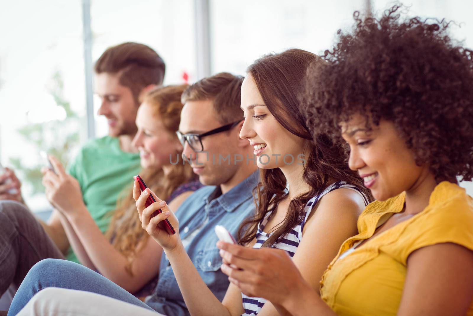 Fashion students looking at their smartphone at the college