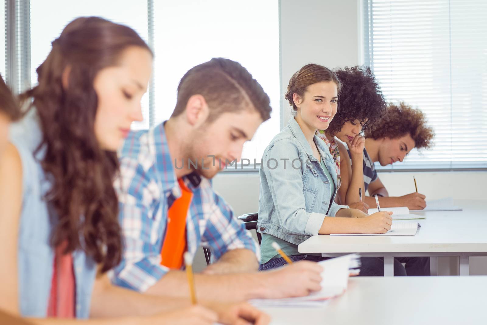 Fashion student smiling at camera in class at the college