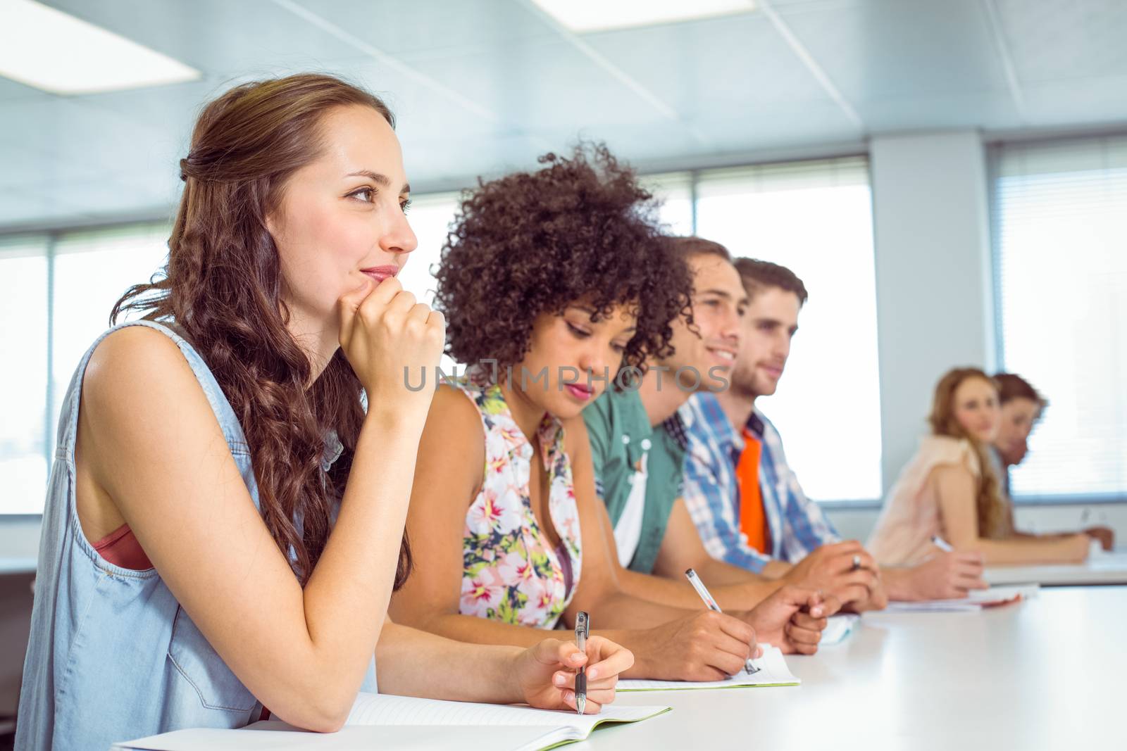 Fashion students taking notes in class by Wavebreakmedia