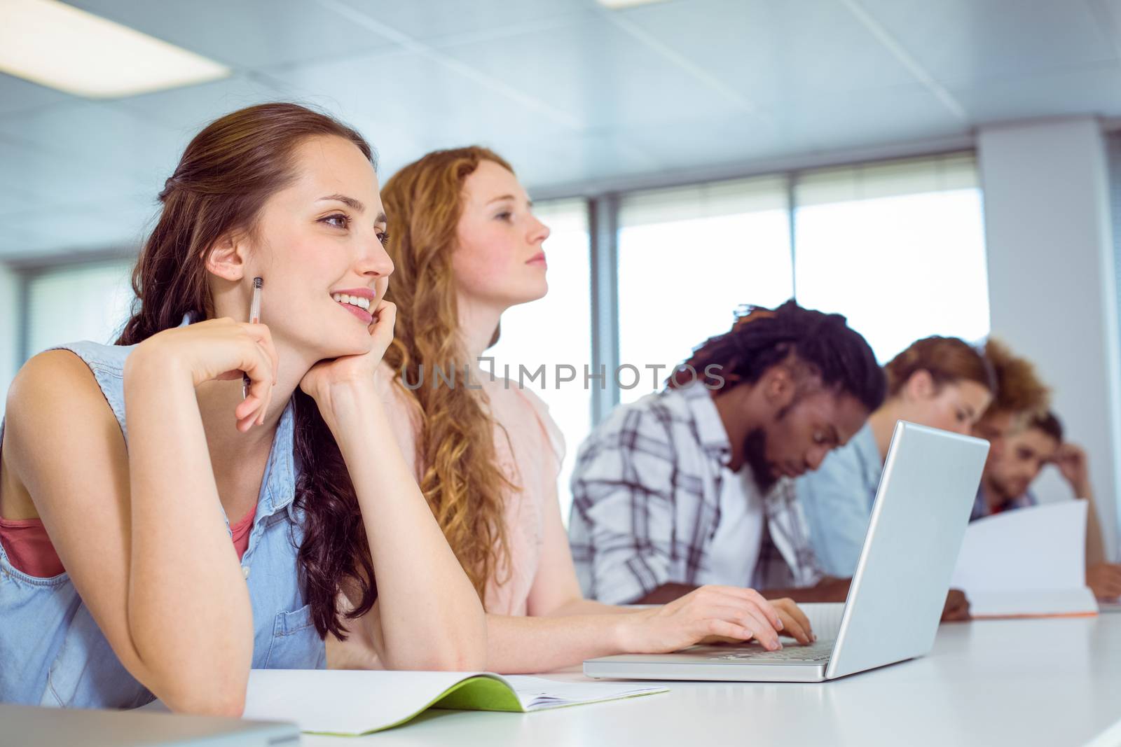 Fashion students taking notes in class by Wavebreakmedia