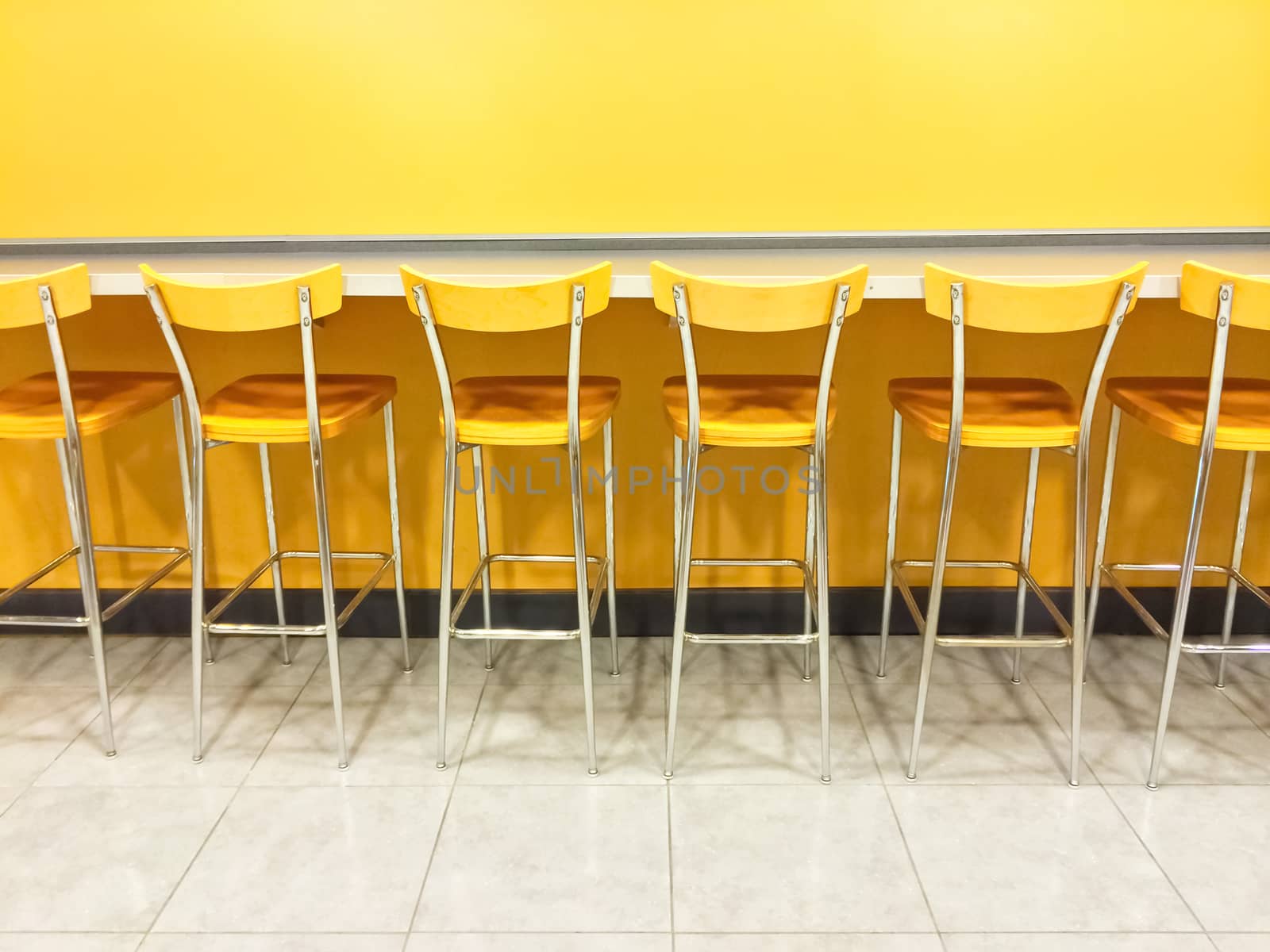 Raw of empty yellow chairs in a cafeteria.