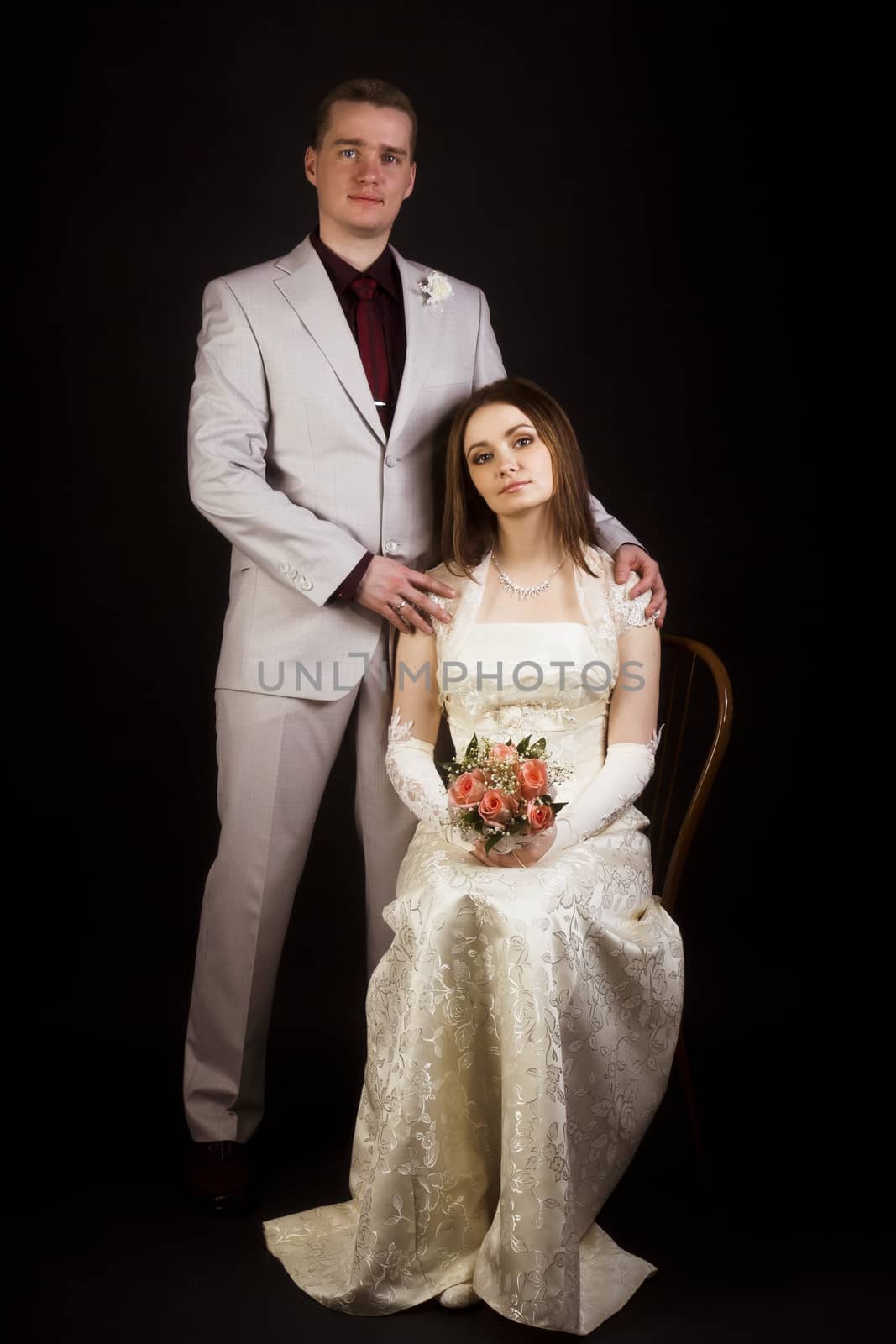 Wedding photo studio. Young beautiful couple on a black background.