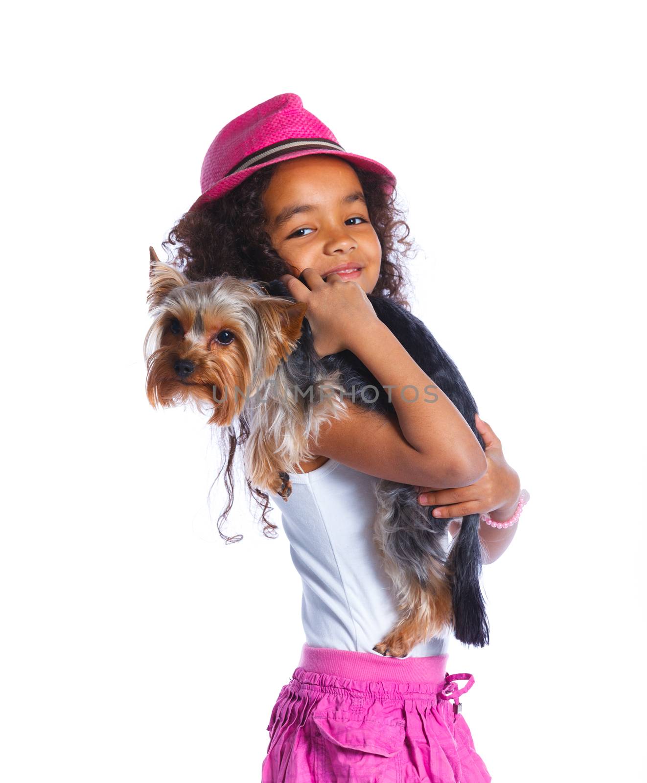 Cute little girl sitting with his puppy Yorkshire terrier smiling at camera on white background