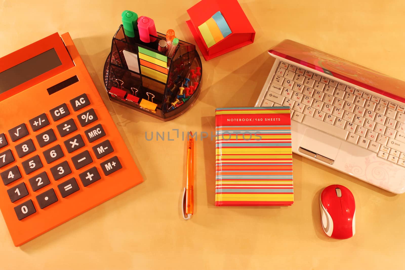 Calculator, daily planner and orange colored stationery