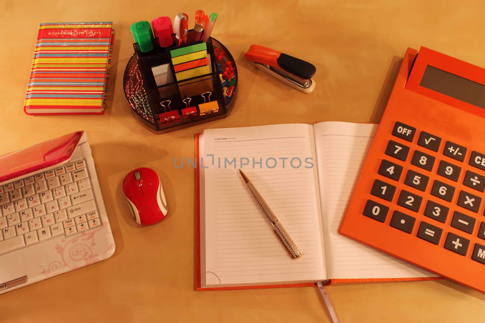 Calculator, daily planner and orange colored stationery