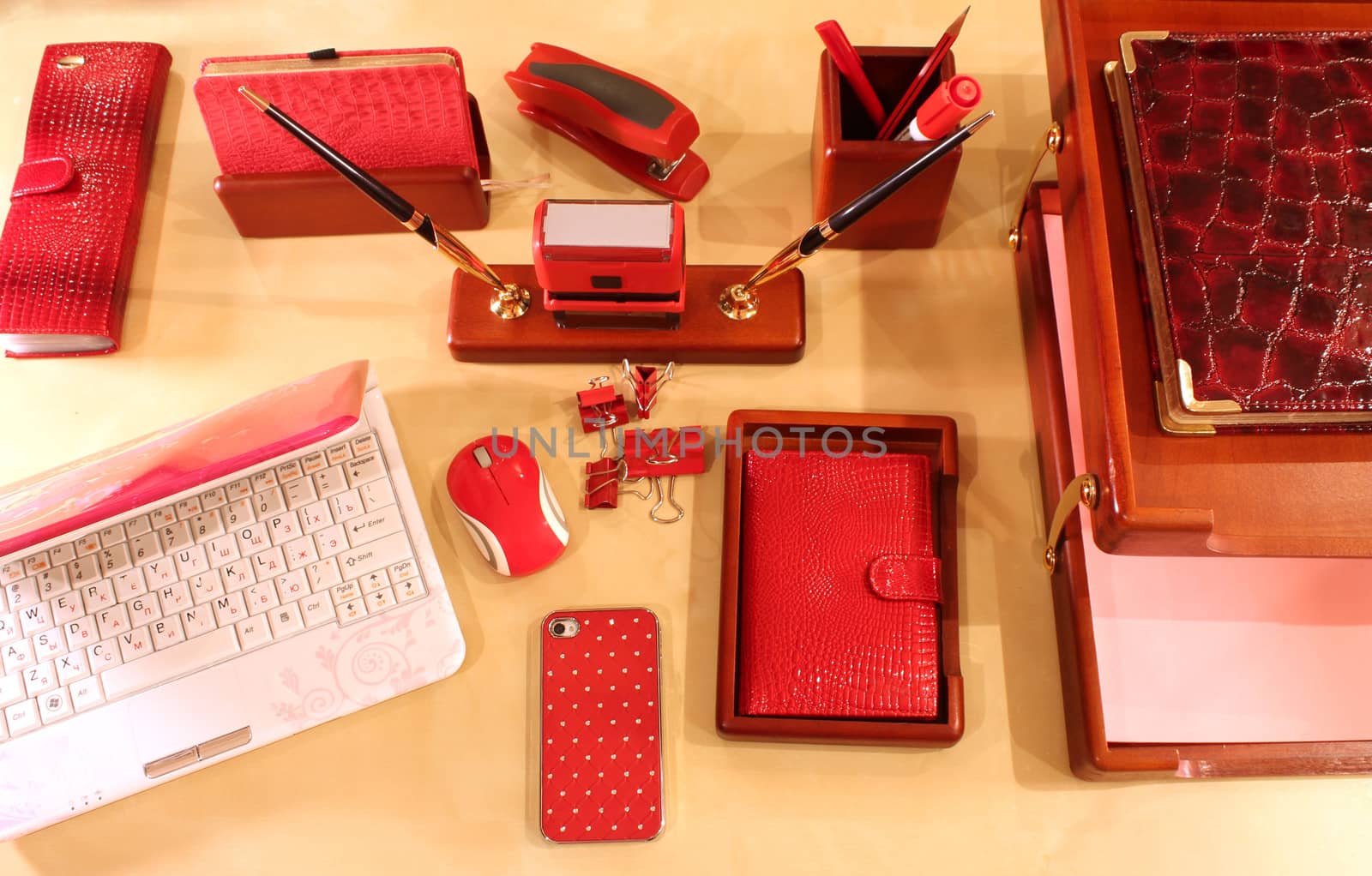 Computer, mobile phone, paper tray and stationery in red color scheme