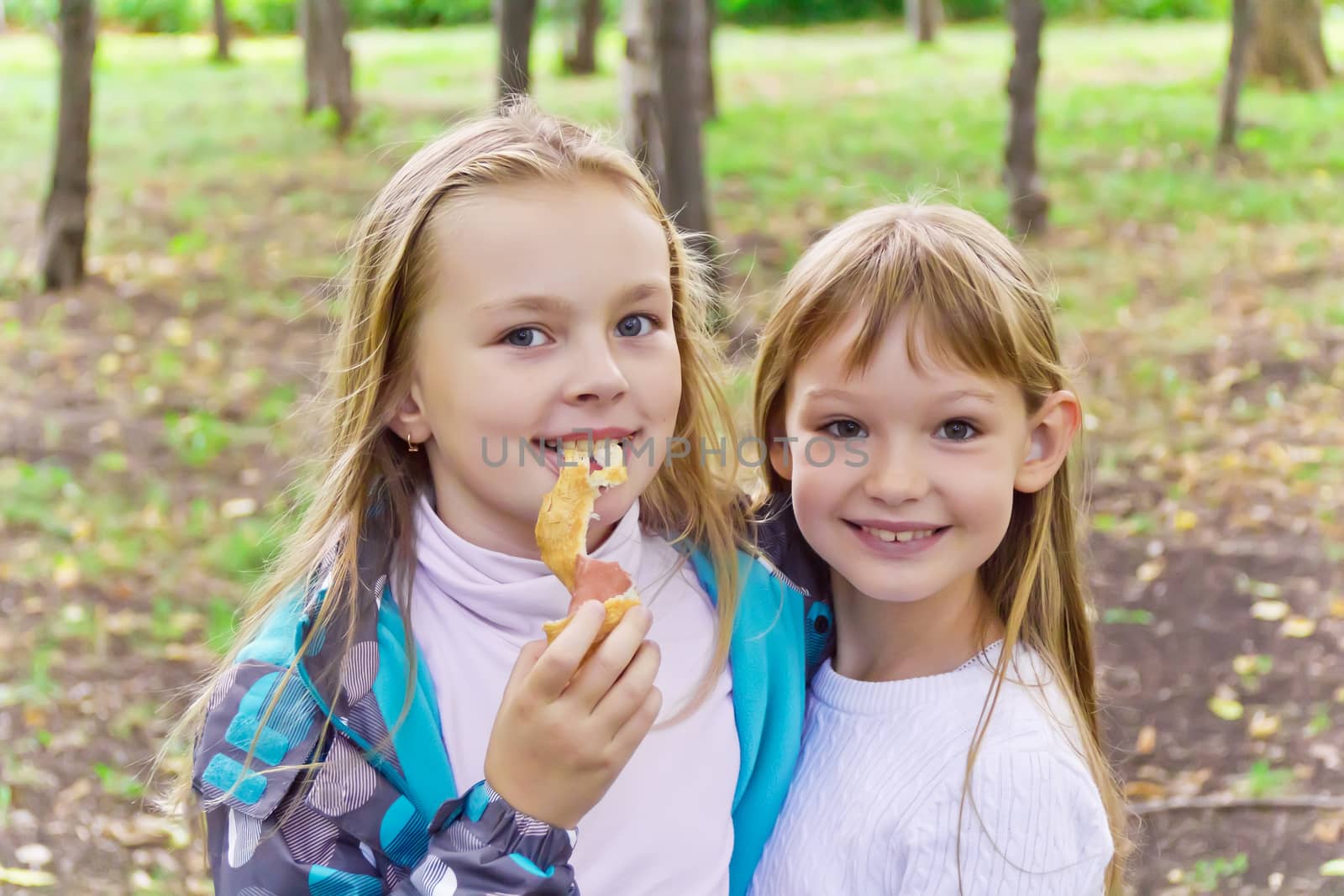 Photo of two eating girls in summer