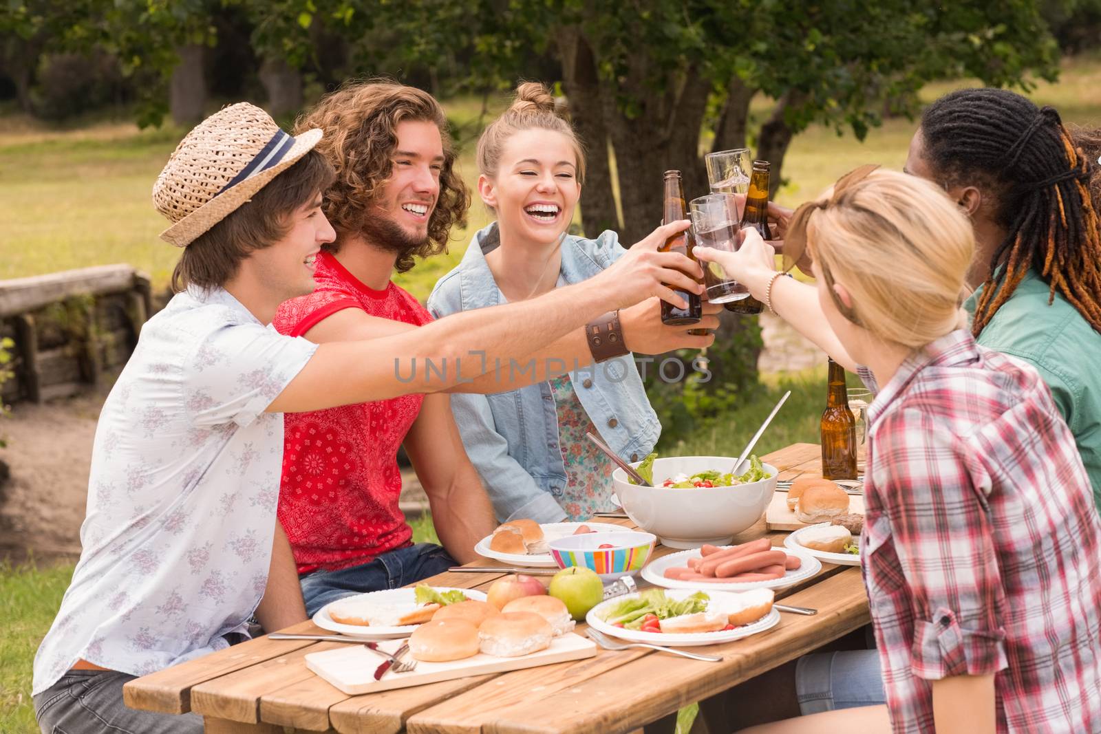 Happy friends in the park having lunch by Wavebreakmedia