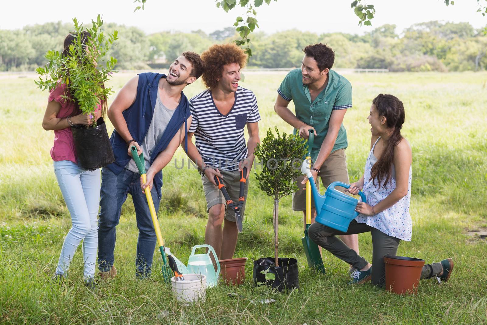 Happy friends gardening for the community on a sunny day