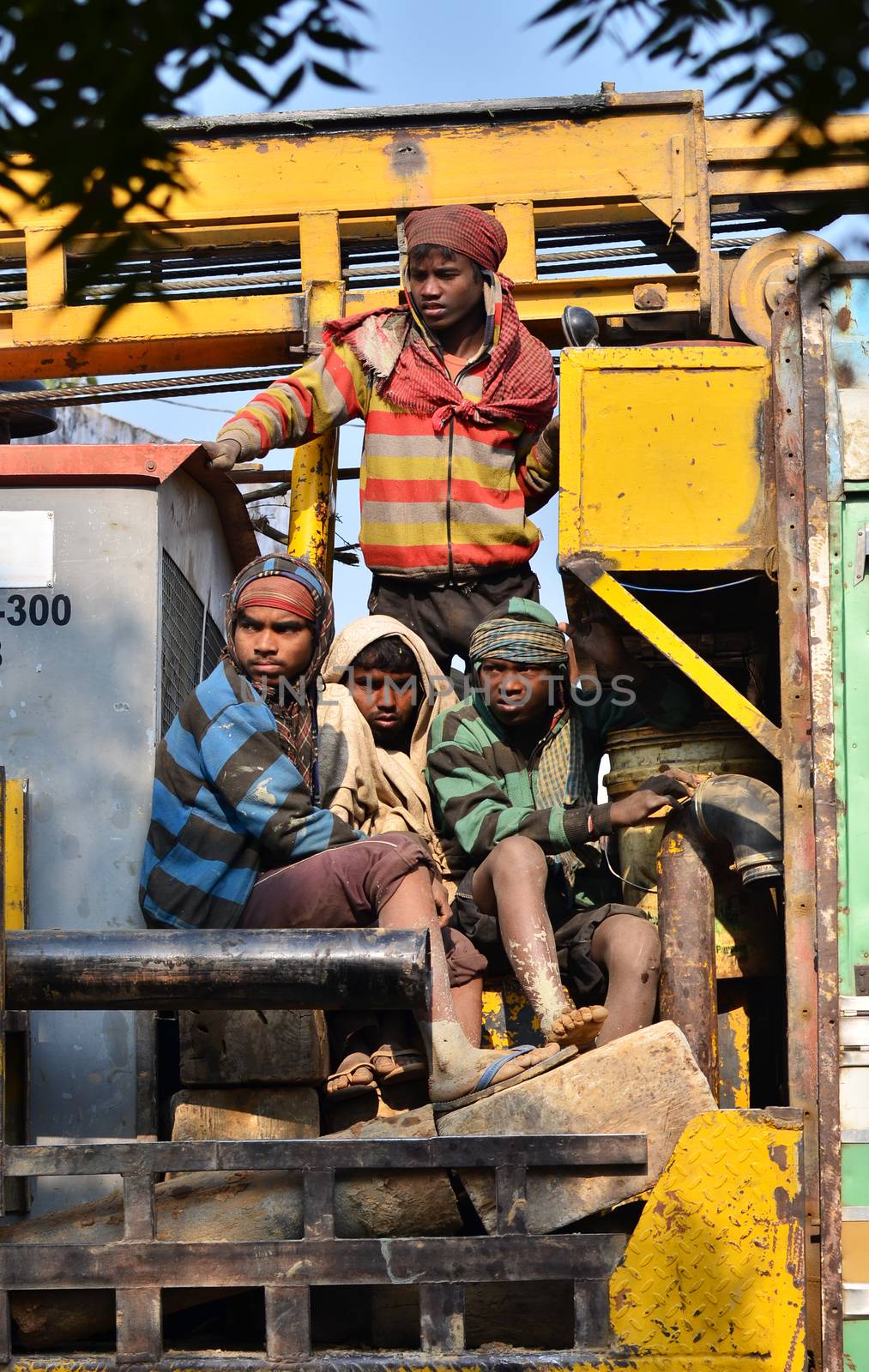 Jaipur, India - December 30, 2014: Unidentified travellers, mostly construction workers on the truck. by siraanamwong