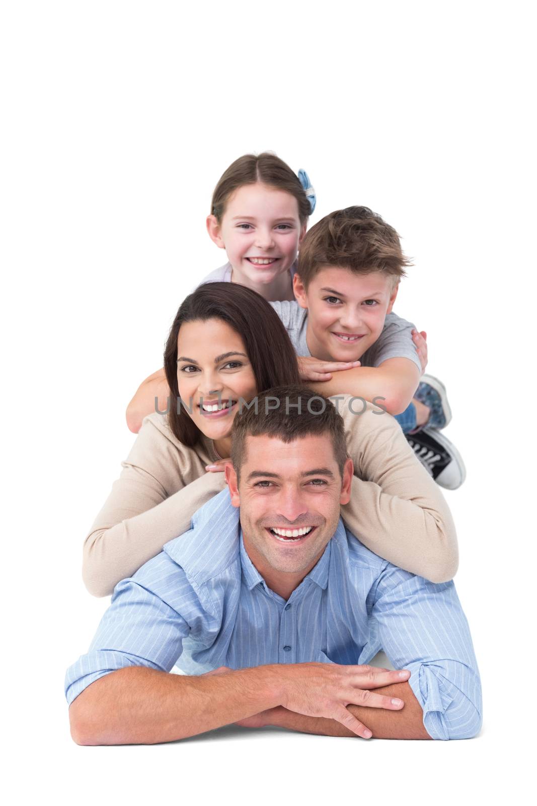 Portrait of happy family lying on top of each other over white background