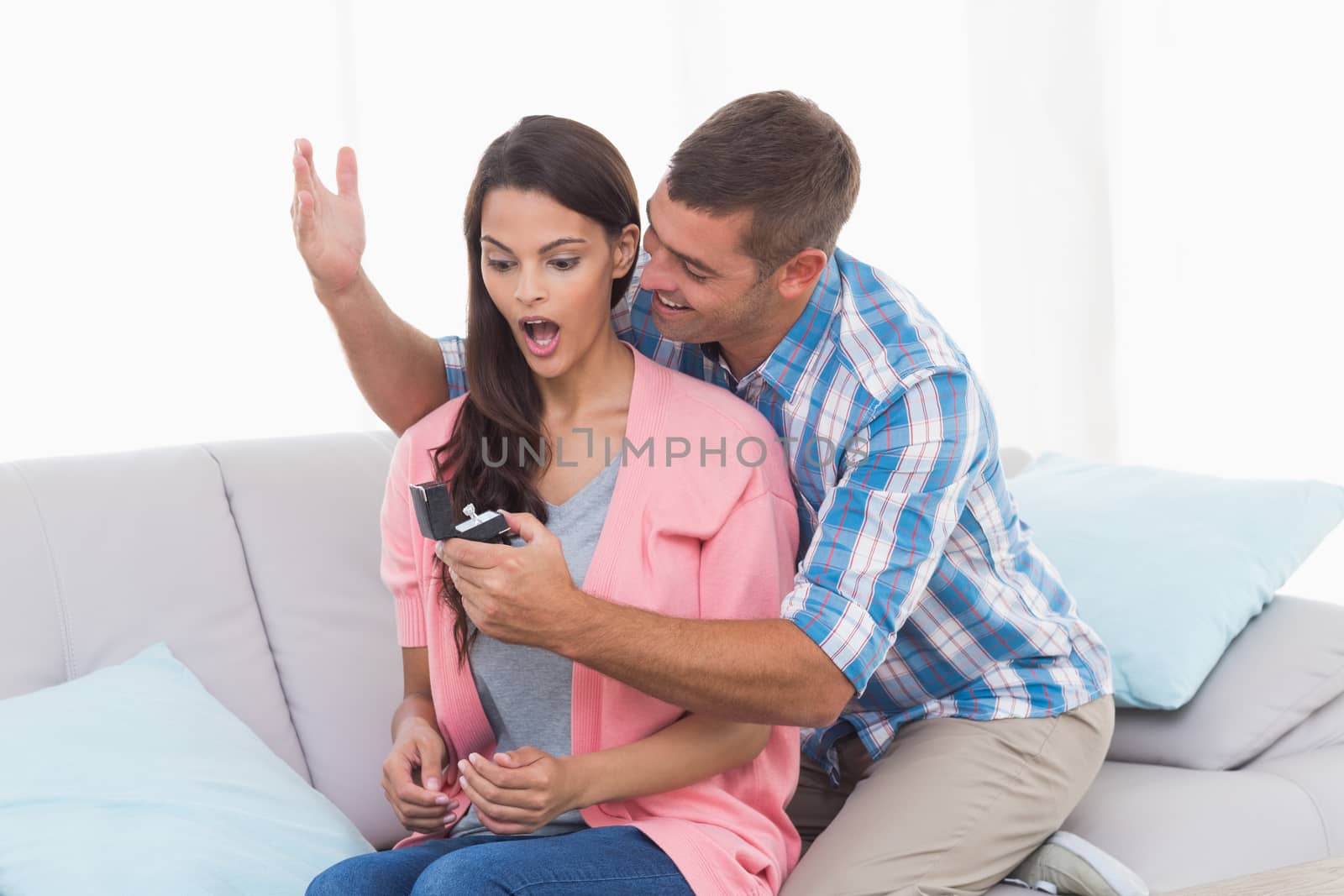 Man gifting ring to surprised woman by Wavebreakmedia