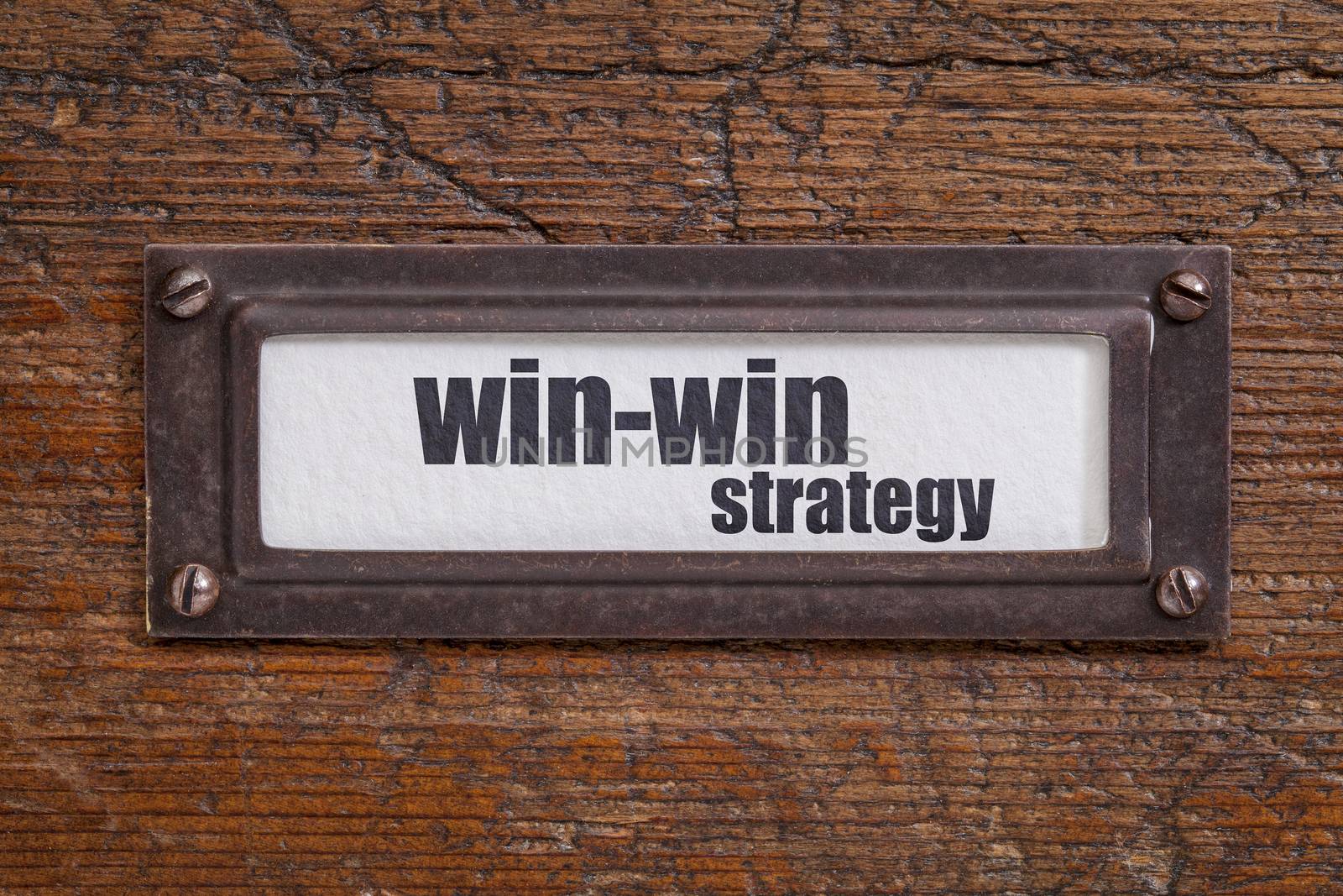 win-win strategy  - file cabinet label, bronze holder against grunge and scratched wood