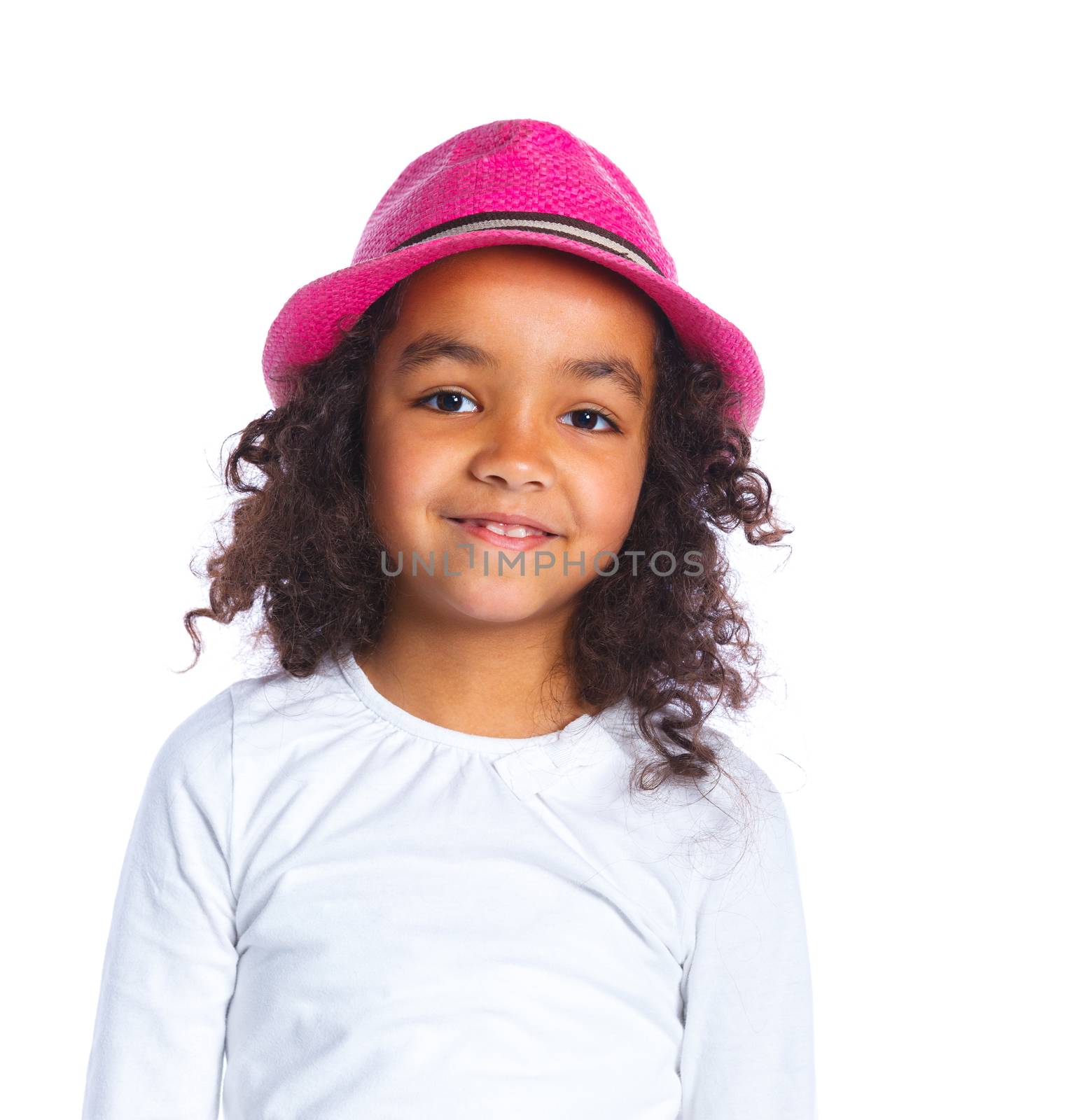 Closeup portrait of a pretty mulatto girl in pink hat smiling at camera on white background