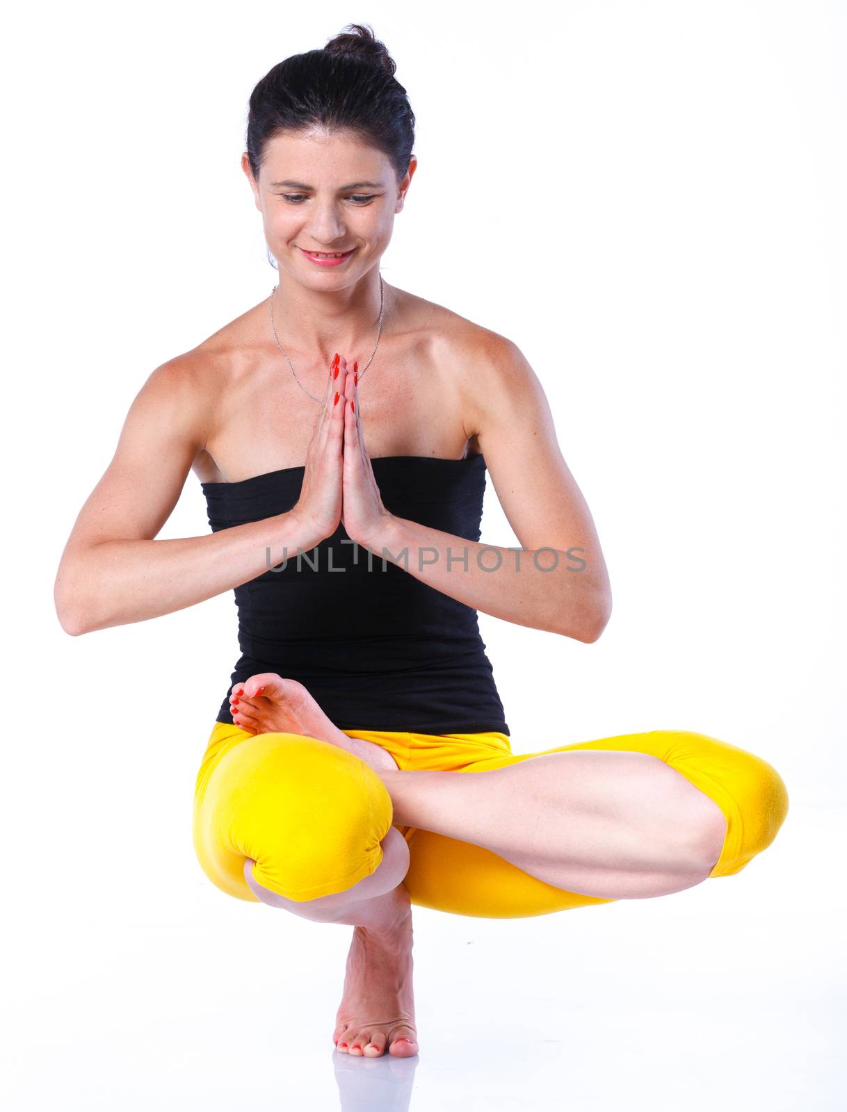 Yoga woman - pretty brunette in active wear doing yoga on white background