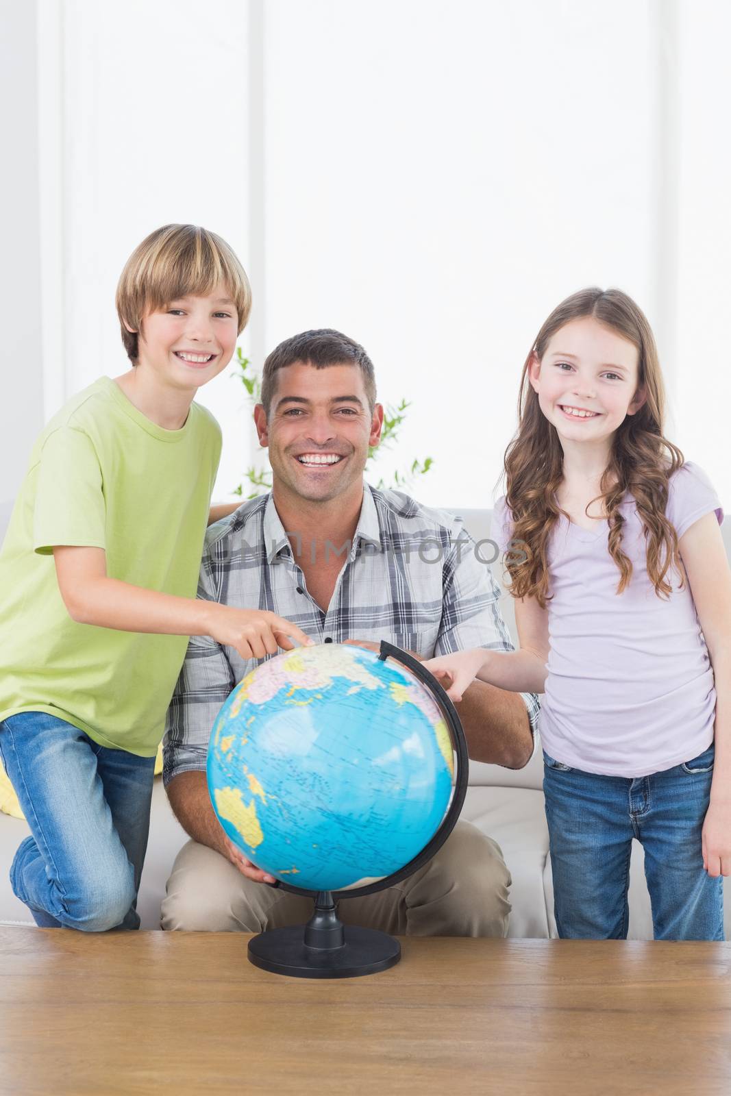 Father with son and daughter exploring map on globe by Wavebreakmedia