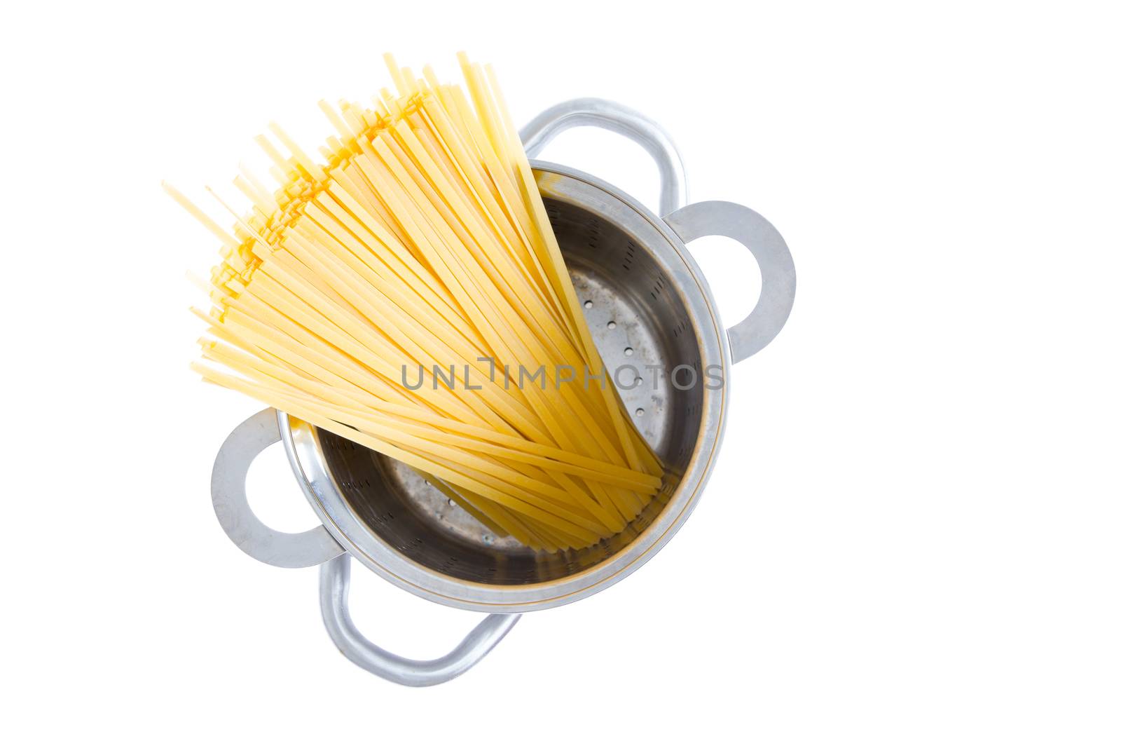 Overhead view of a bundle of dried fettuccine pasta standing upright in a pot ready for boiling for an Italian pasta recipe, isolated on white