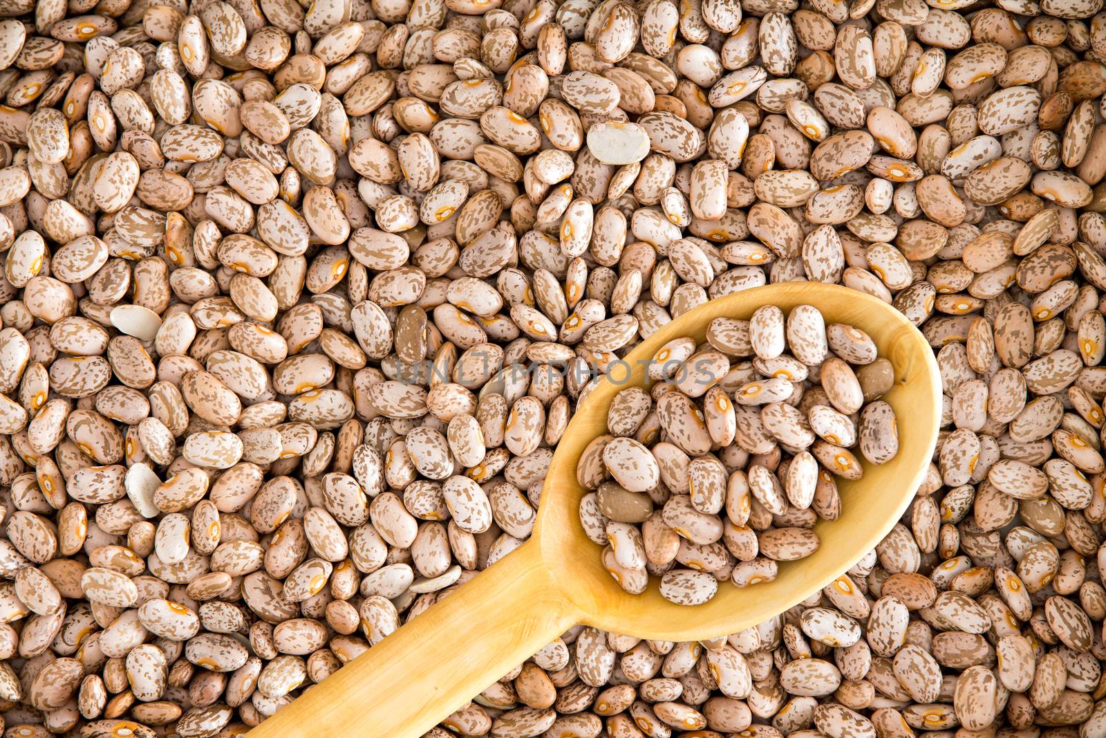 Close up Plenty of Rich in Fiber and Fat Free Brown Pinto Beans with Wooden Spoon. Used for Wallpaper Backgrounds.