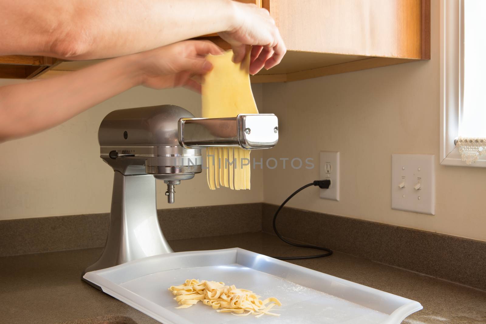 Man making homemade fettuccine pasta by coskun