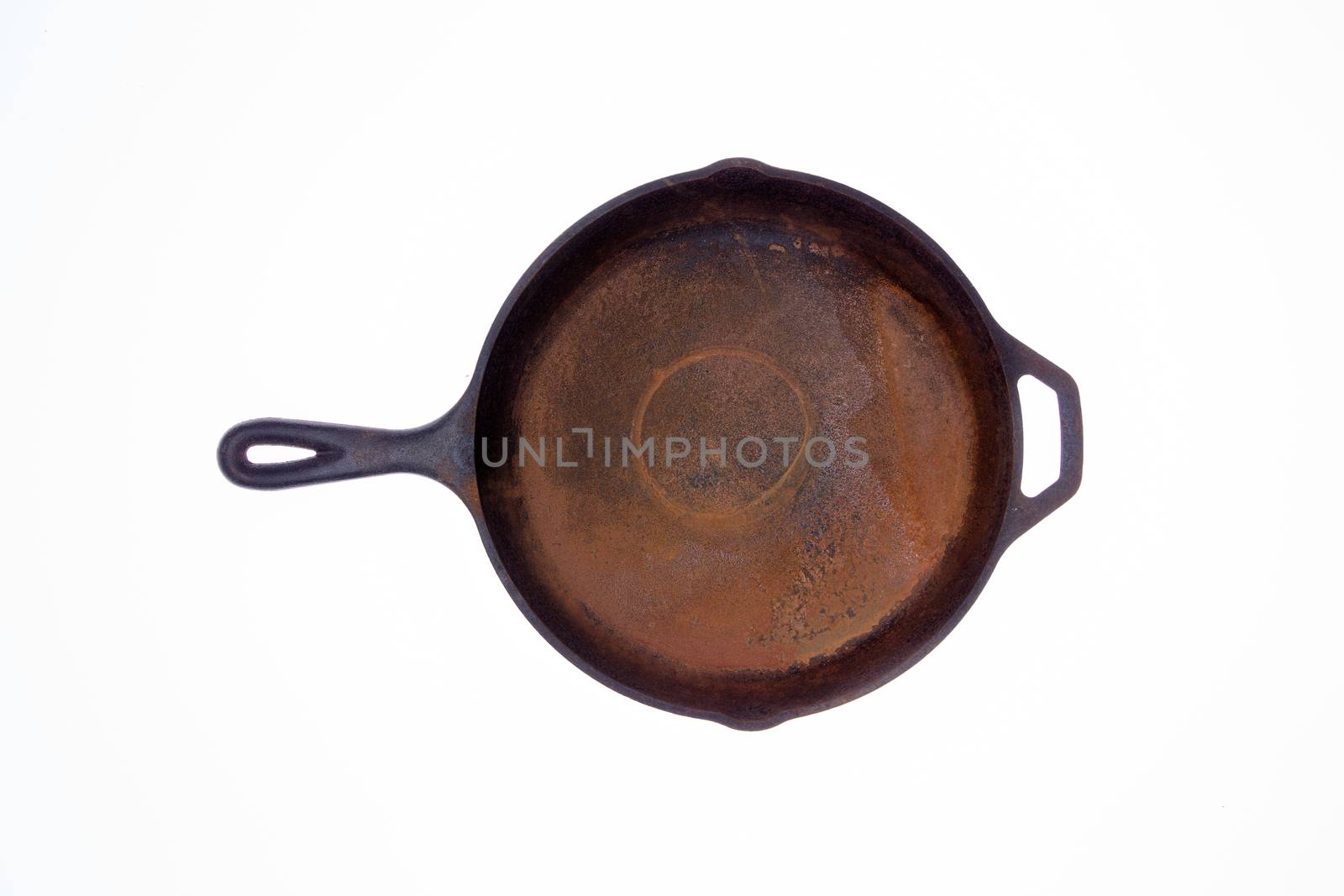 Old rusty round black cast iron frying pan viewed from above isolated on a white background centered in the frame