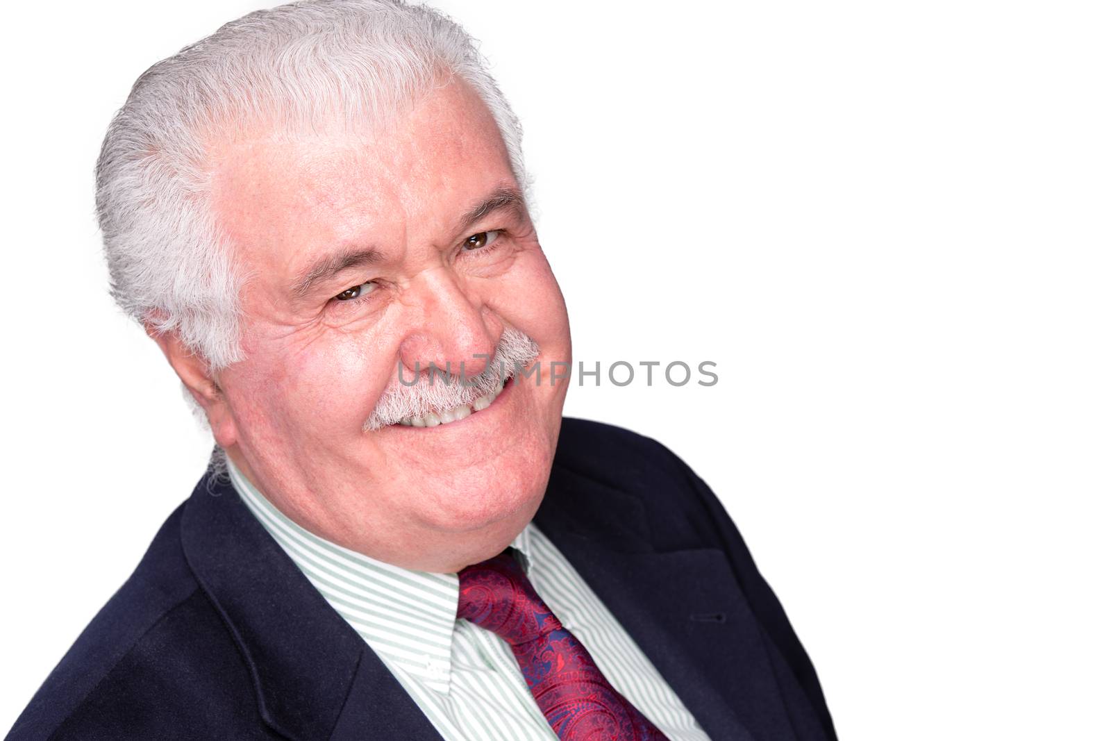 Jovial distinguished charismatic elderly grey-haired man looking at the camera with a happy beaming smile, isolated on white