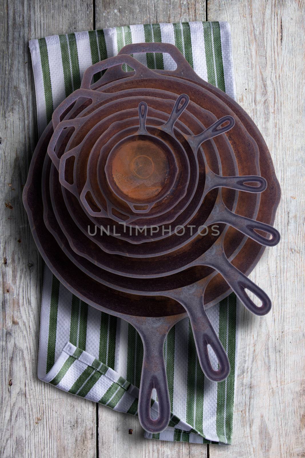 Collection of round rusty cast iron frying pans by coskun