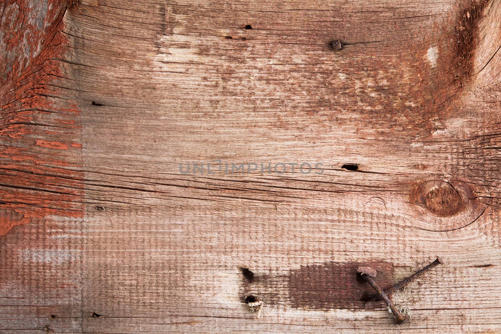 Old weathered battered wood texture with rusty nails, stains and remnants of paint from a demolished building