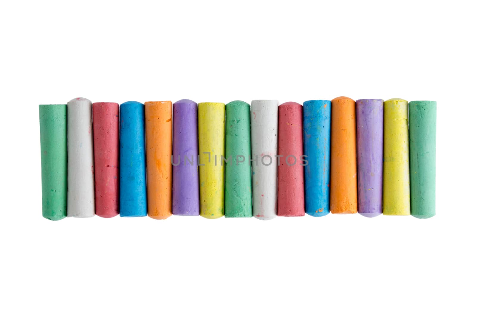 Long row of brightly colored chalk crayons in the colors of the rainbow neatly aligned centered on a white background , view from above