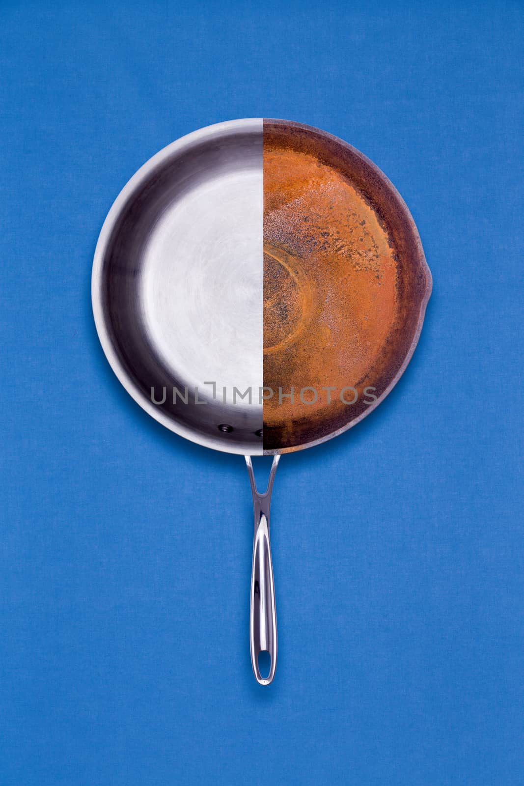 New teflon coated non-stick and old rusted frying pan combined into one halved unit for comparison of age and condition in a conceptual overhead view on a blue background