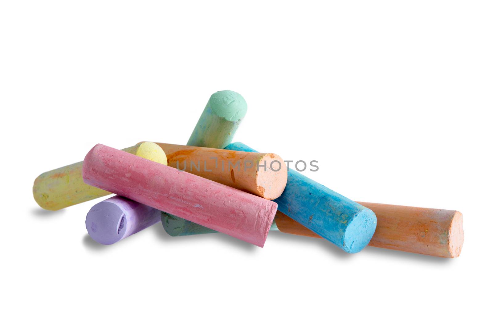 Close up side view of a pile of colorful chalks for kids to play with making erasable drawings, on white with copyspace