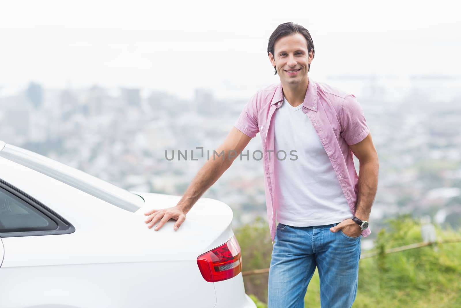 Smiling man standing next to his car  by Wavebreakmedia