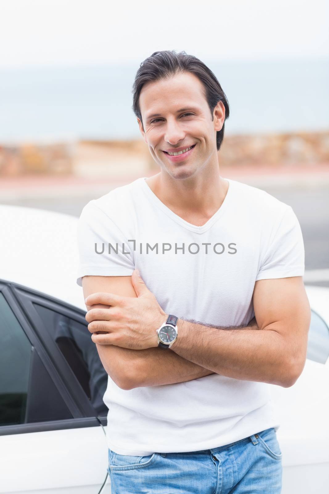 Smiling man leaning on the door of his car