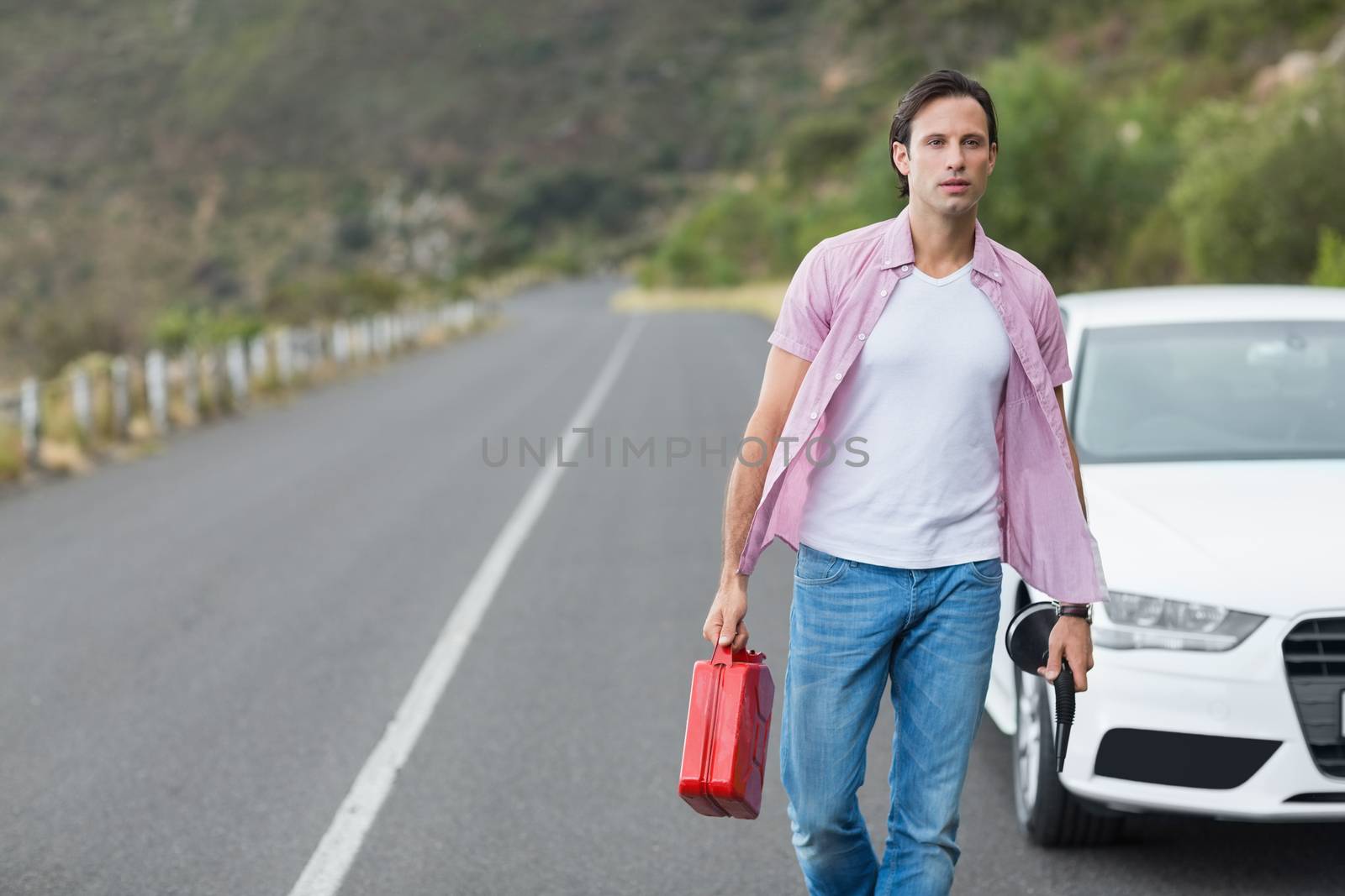 Man walking and holding petrolcan at the side of the road