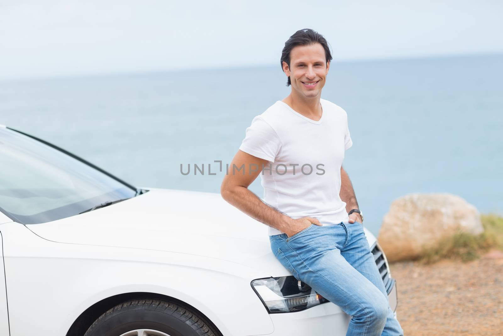 Man smiling at camera outside his car