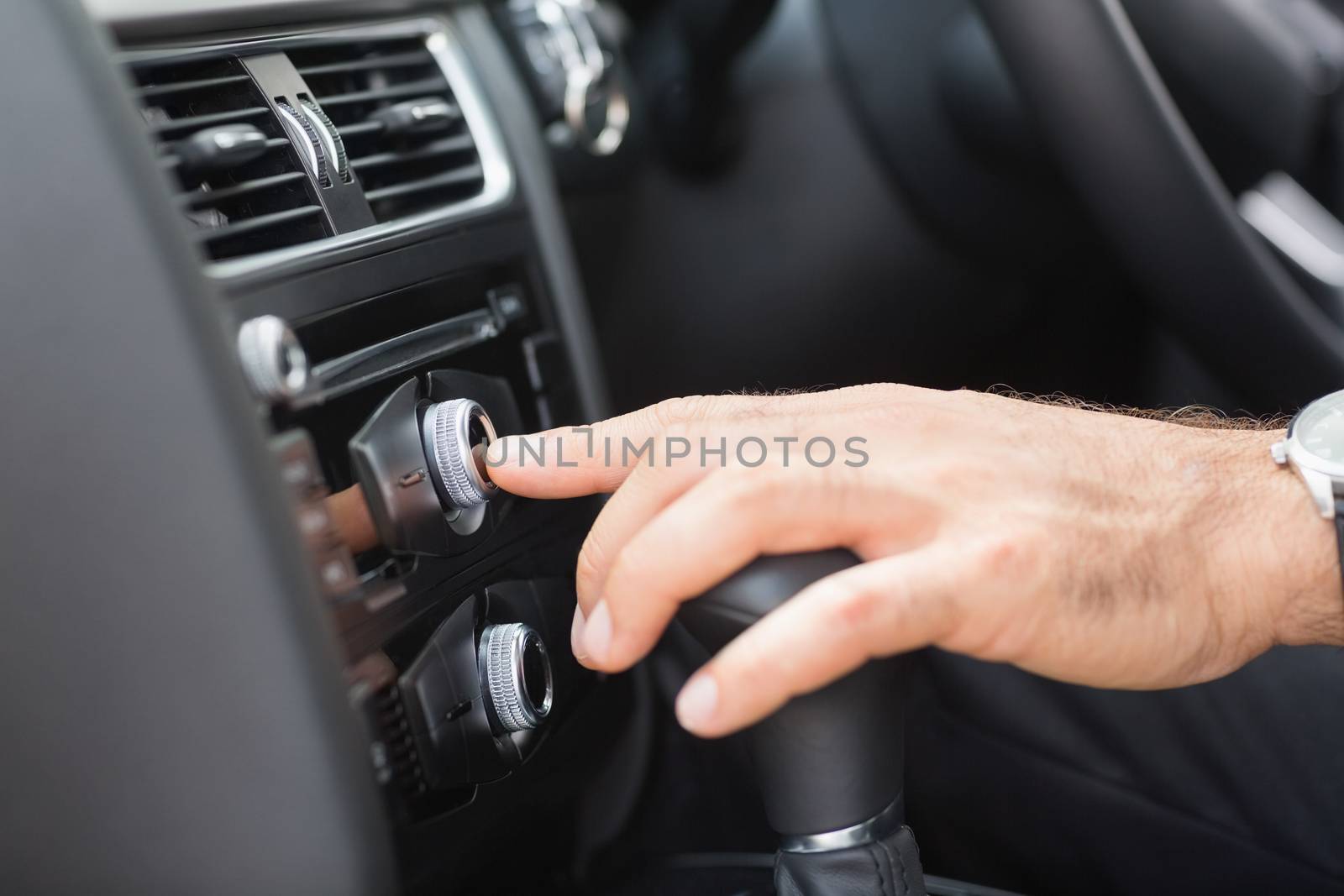 Man pressing a button in his car 
