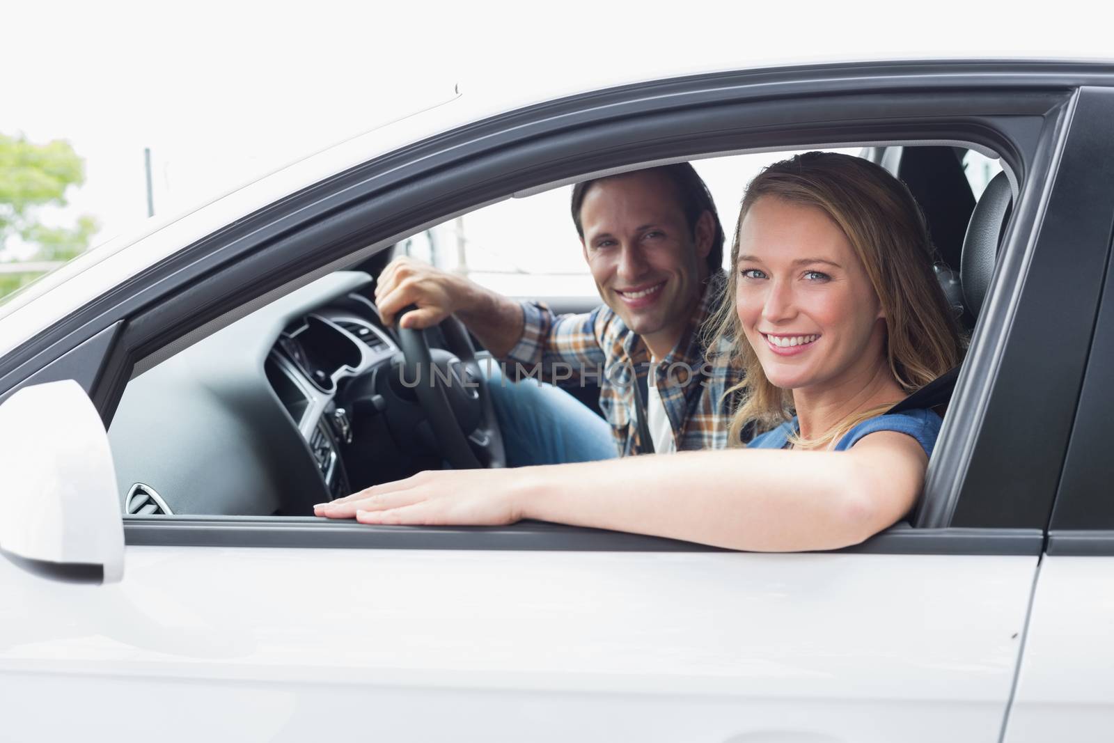 Couple smiling at the camera in their car