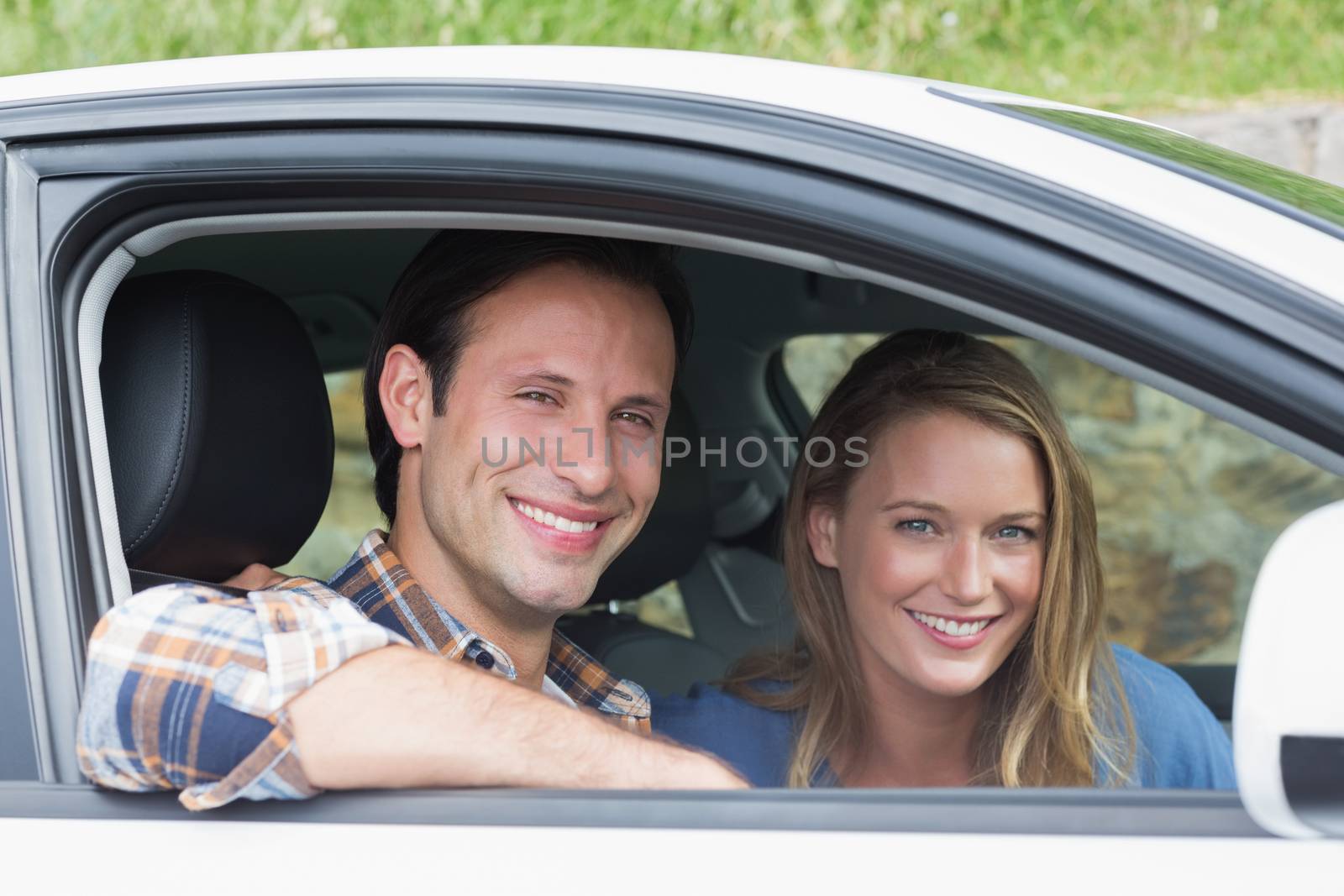 Couple smiling at the camera in their car