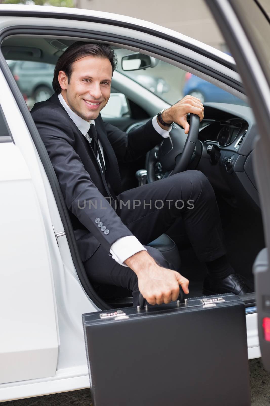 Businessman getting out the front door in his car