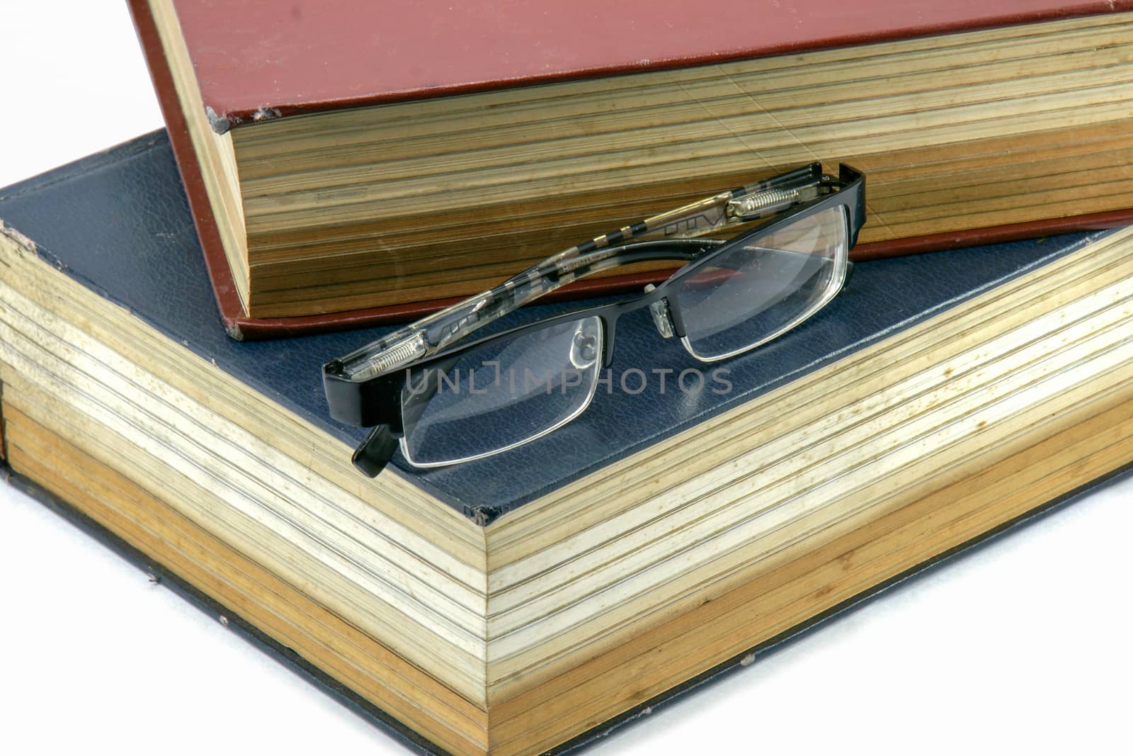 Old text books or bible with eyeglasses on them