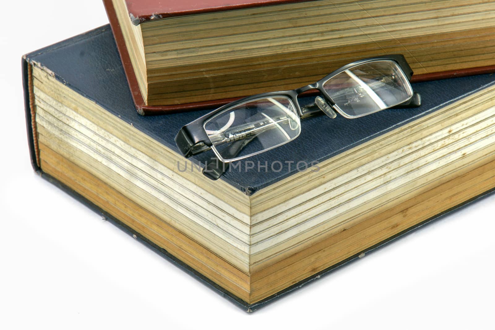 Old text books or bible with eyeglasses on them