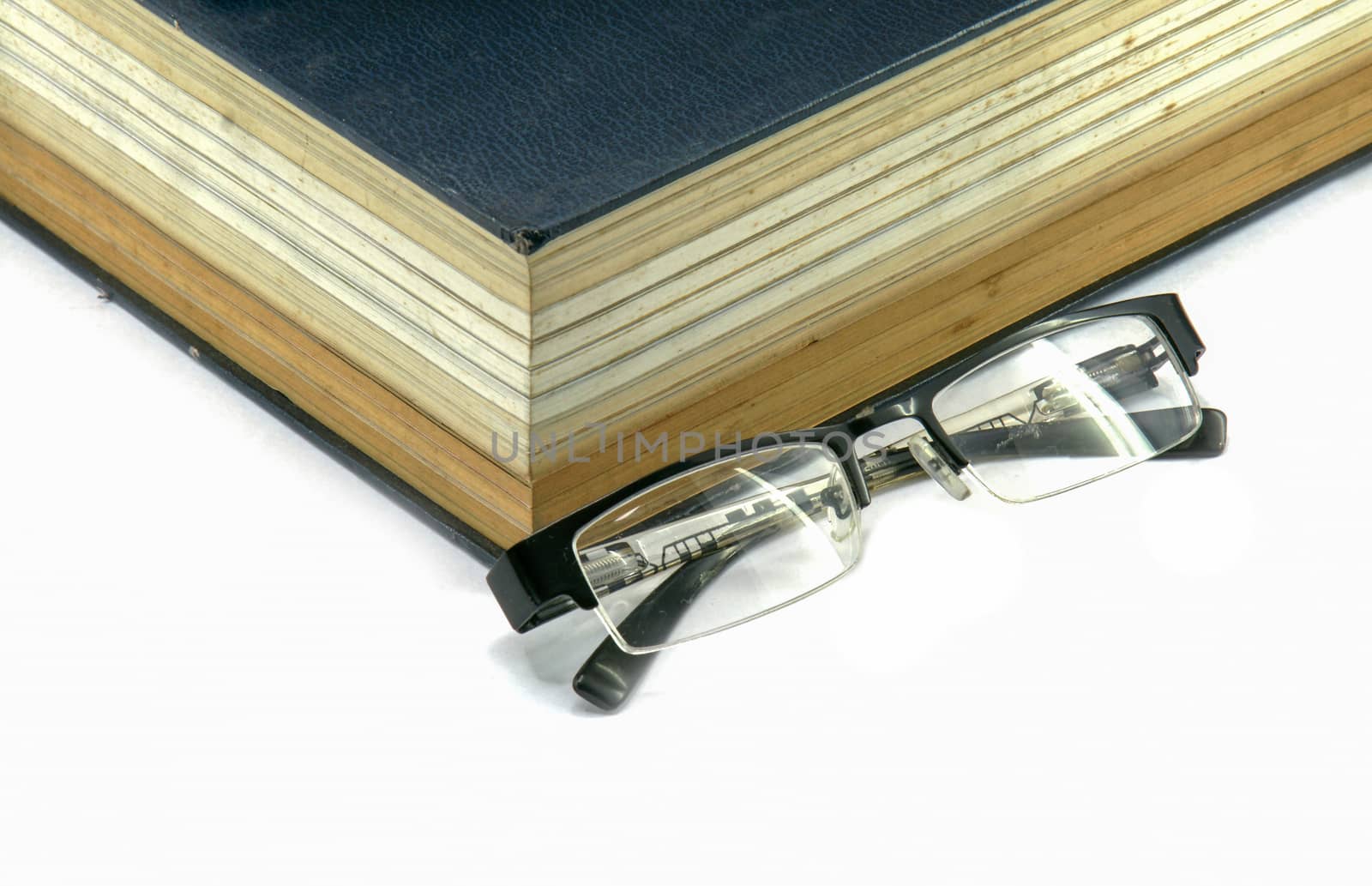 Old text book or bible with eyeglasses by mranucha