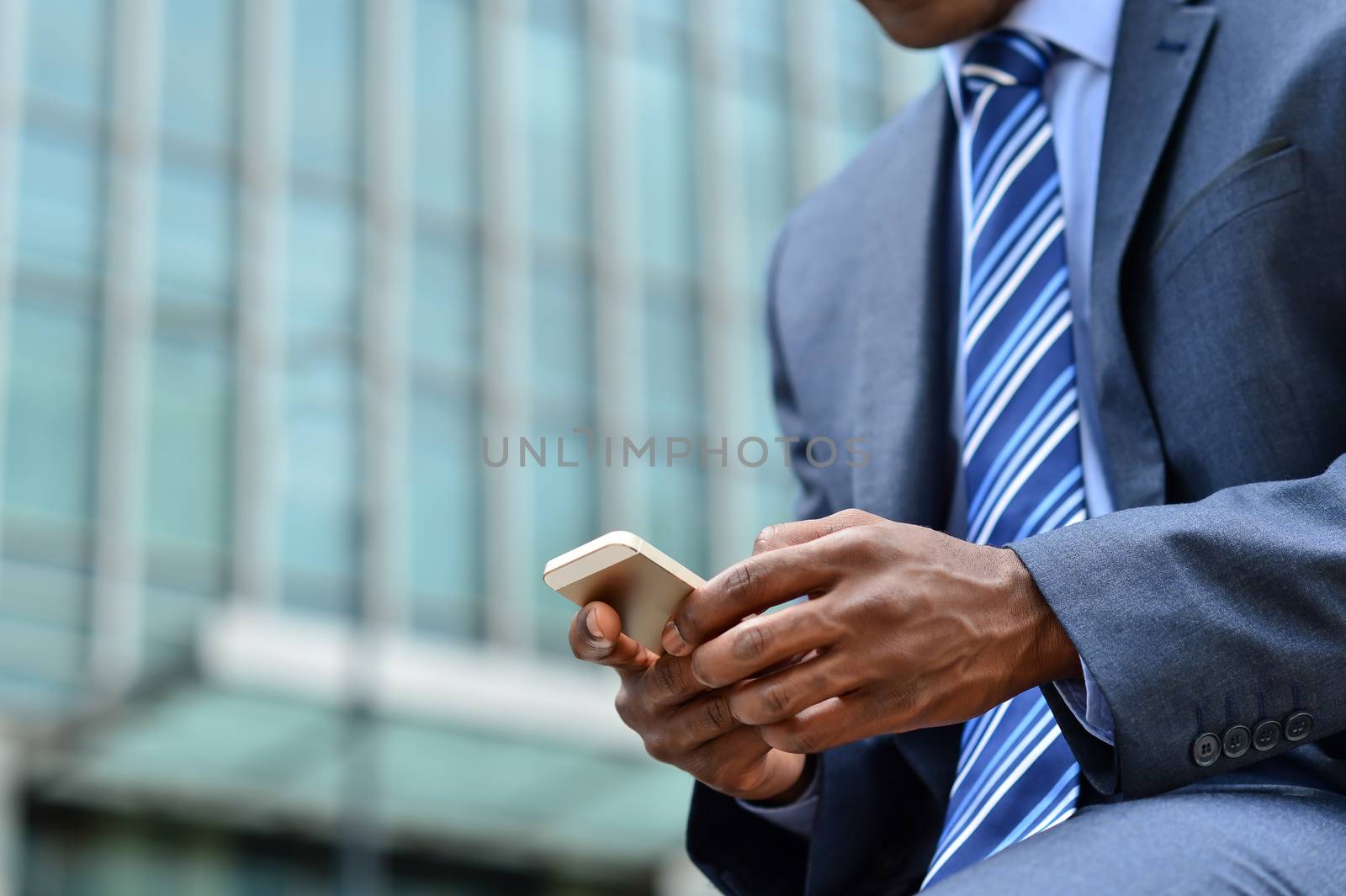 Cropped image of businessman sending messages via mobile