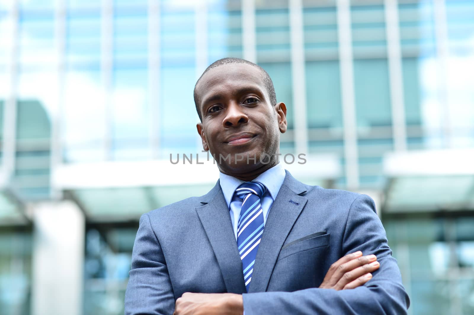 Arms crossed businessman posing at outdoors