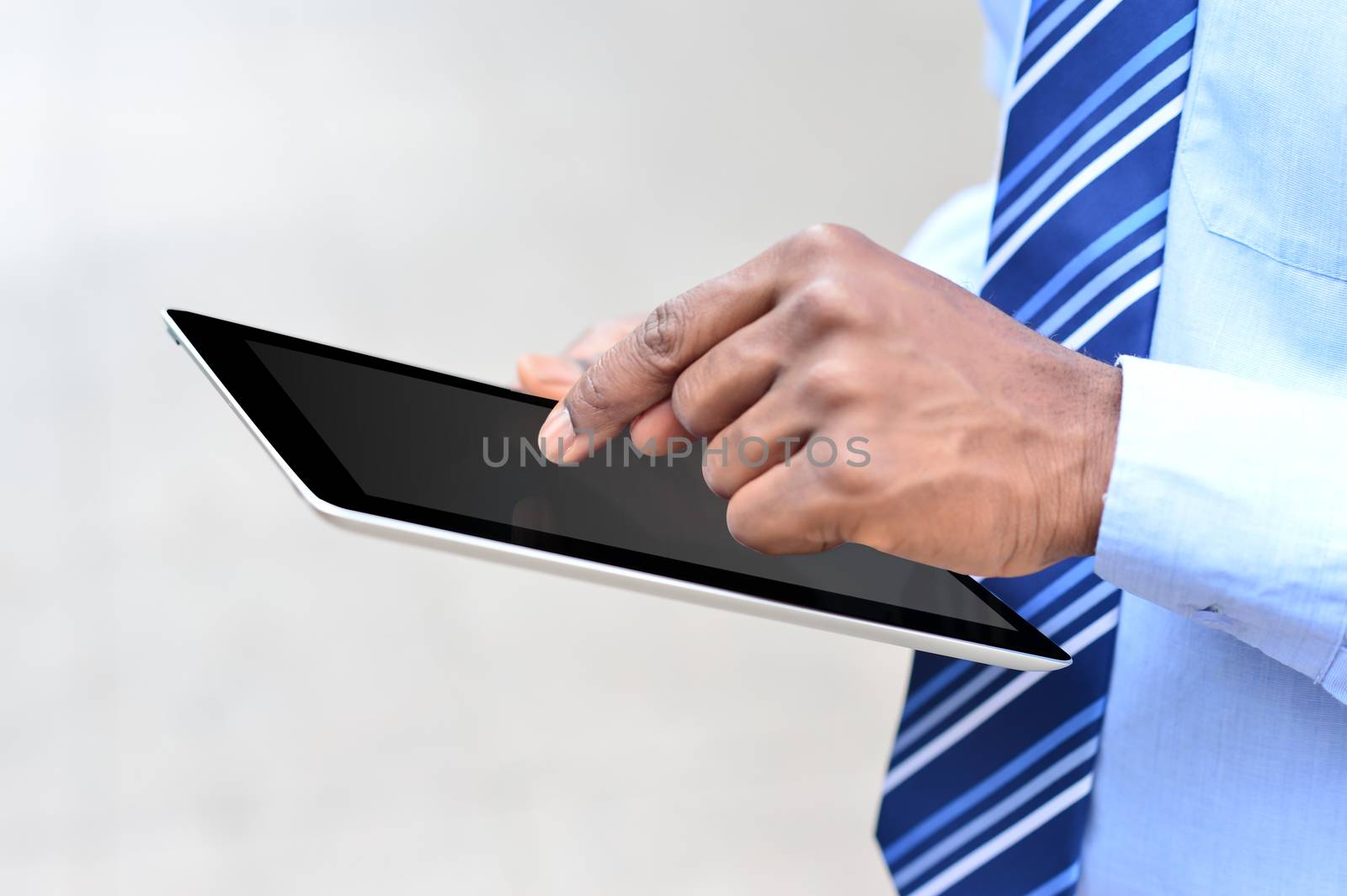 Cropped image of male executive working in tablet