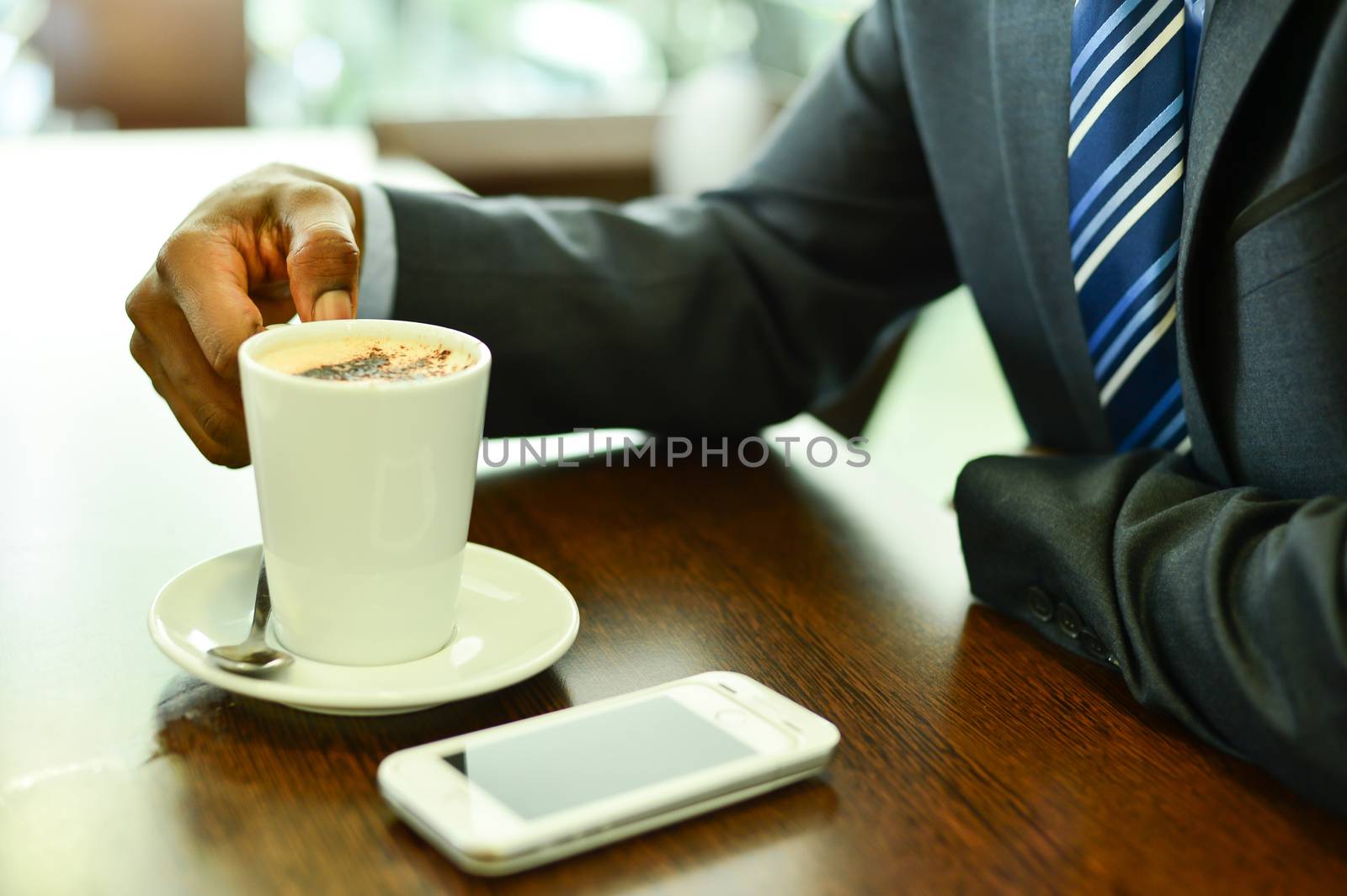 Close up of mobile phone and coffee cup at cafe
