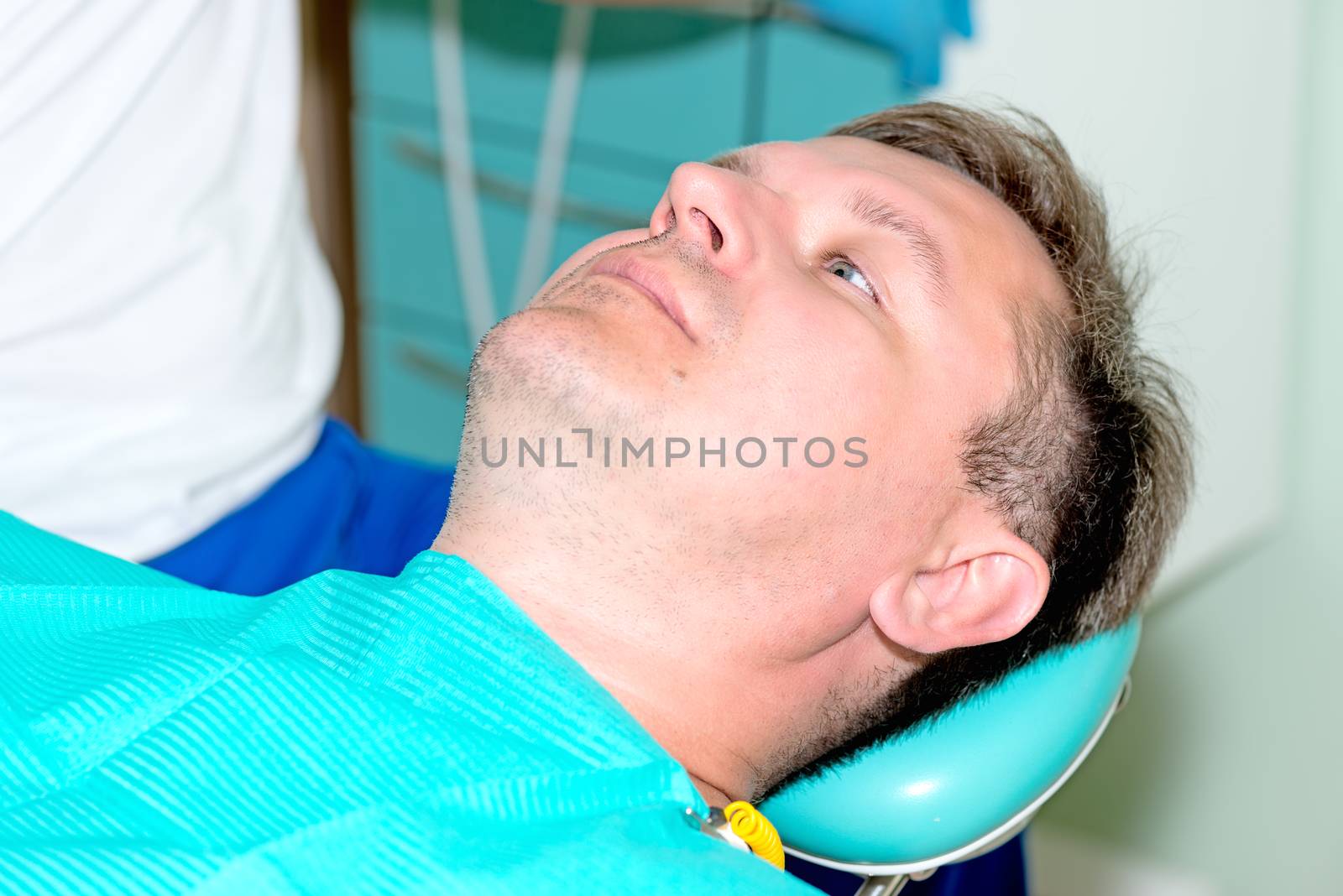 man in dentist office waiting for procedure by Nanisimova